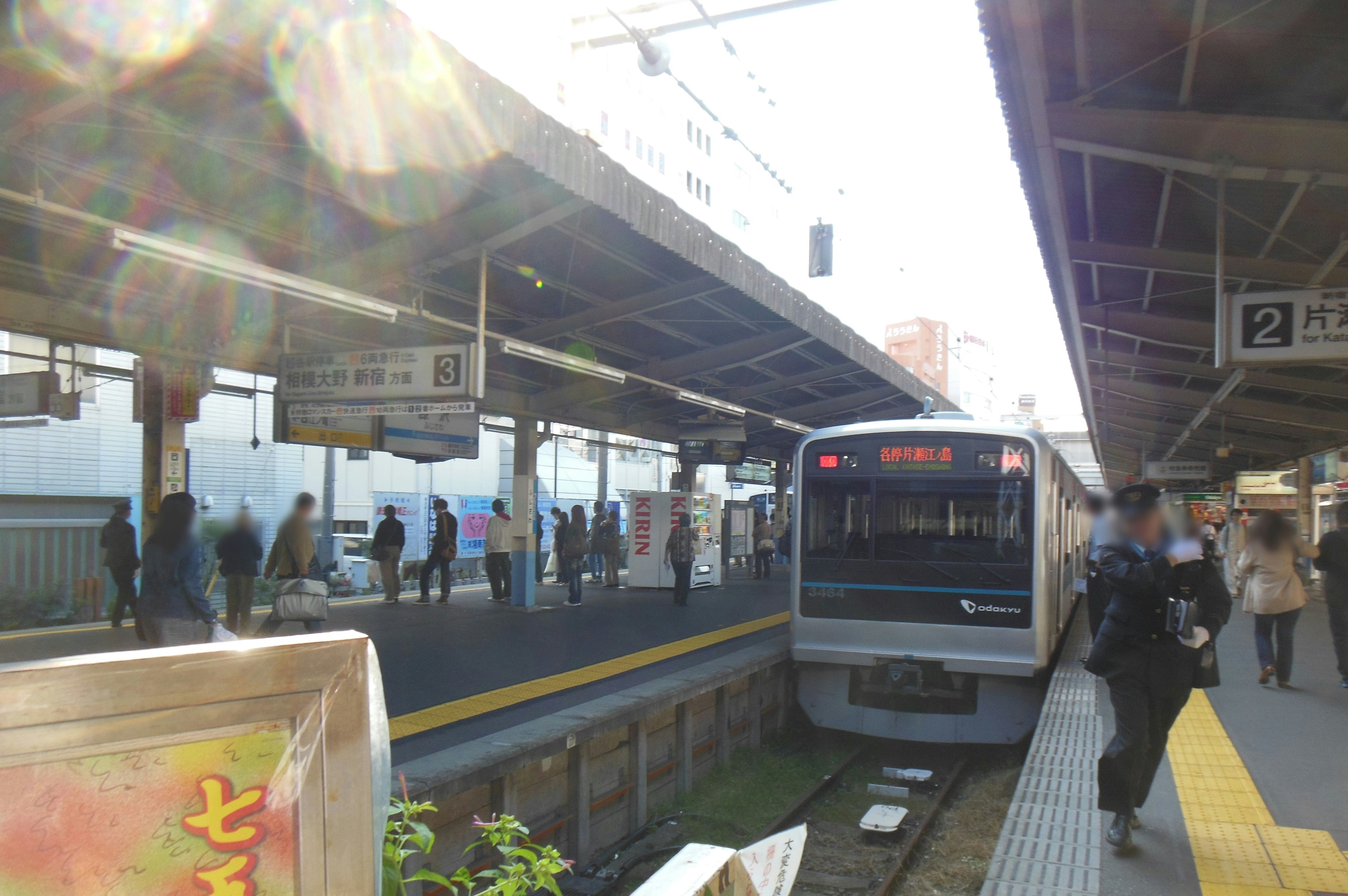 ホームで停車する電車と通勤客のいる駅の風景