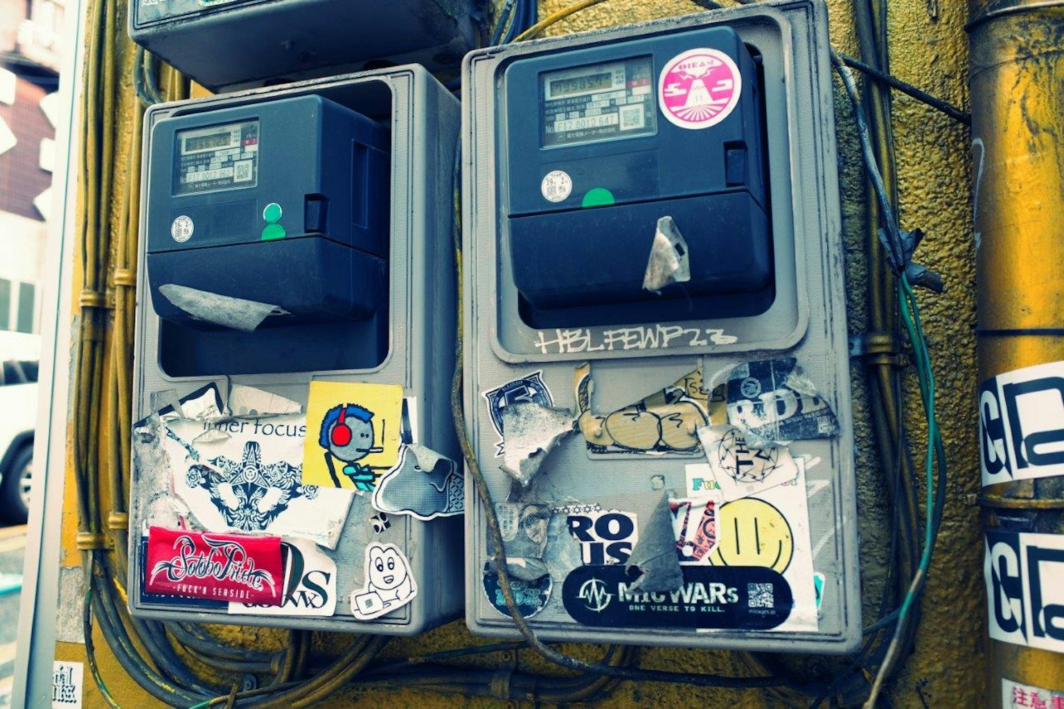 Vecchi parcometri coperti di adesivi colorati e graffiti