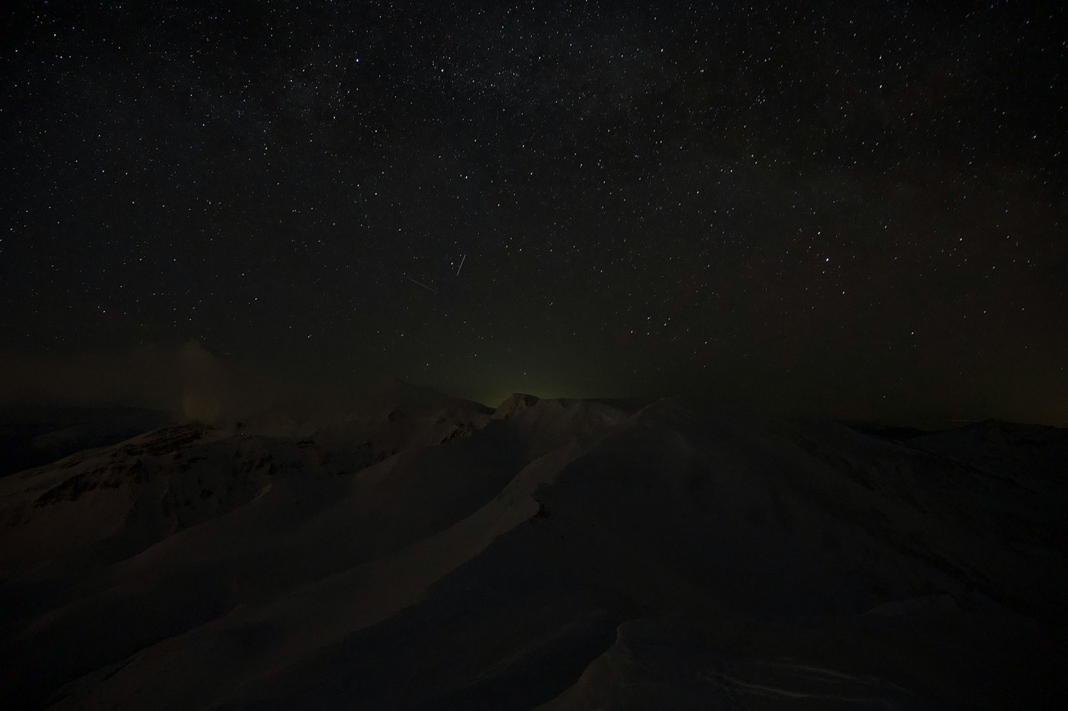 Paysage nocturne avec un ciel étoilé et des montagnes enneigées