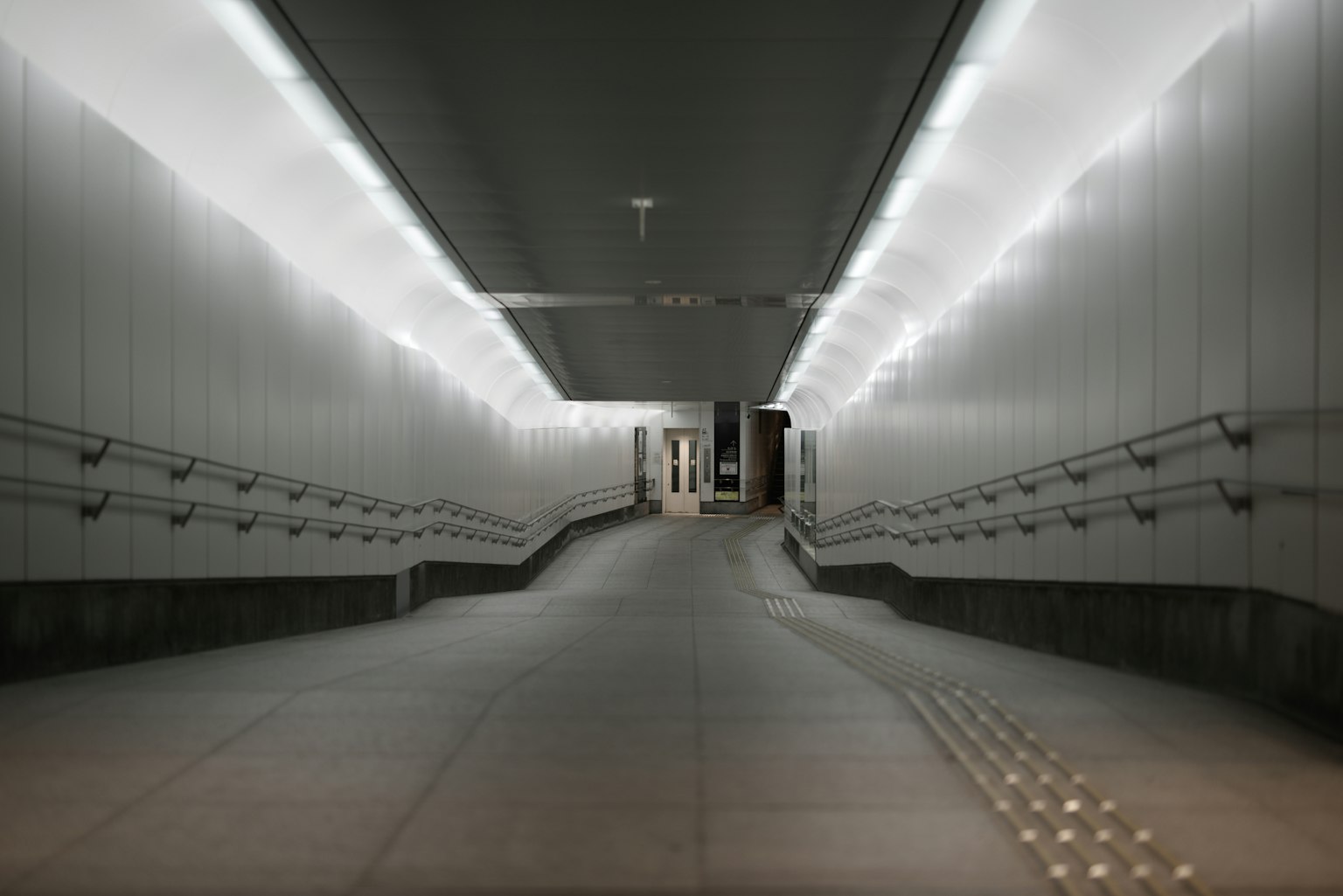 Interior jalan bawah tanah yang terang dengan ramp melengkung