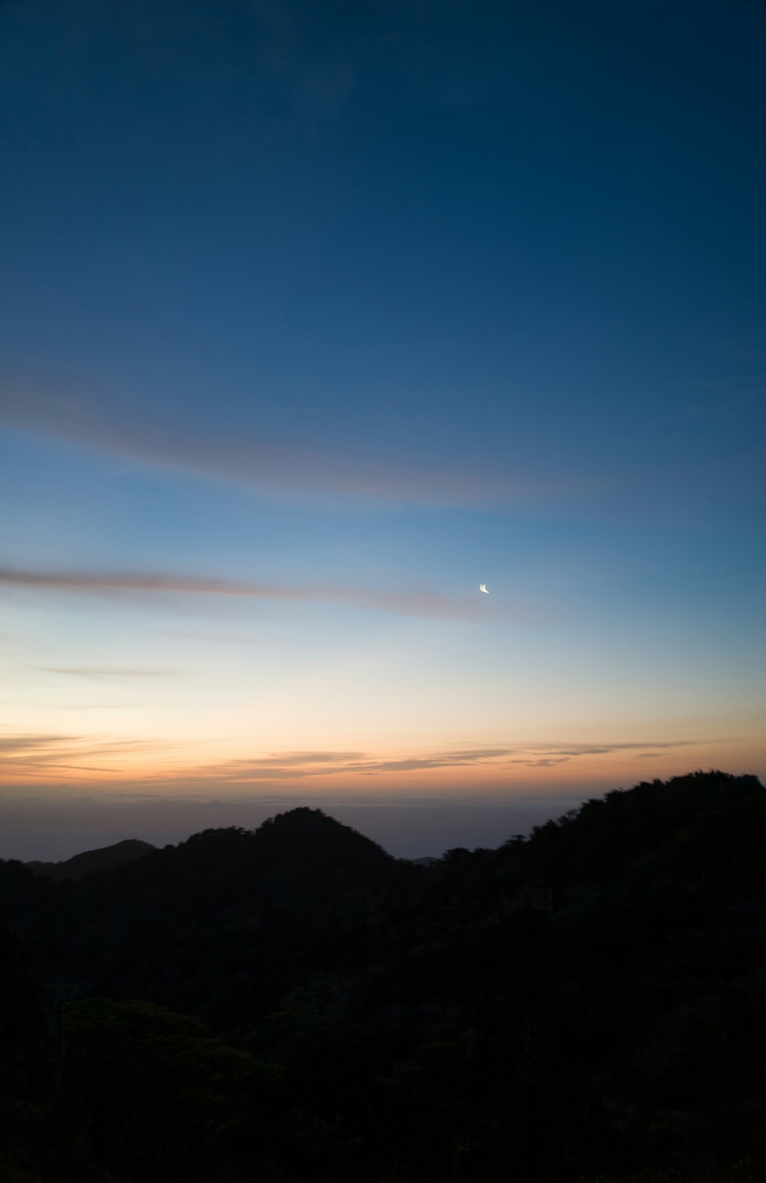 A landscape of sunset with blue sky and gradients of orange and pink