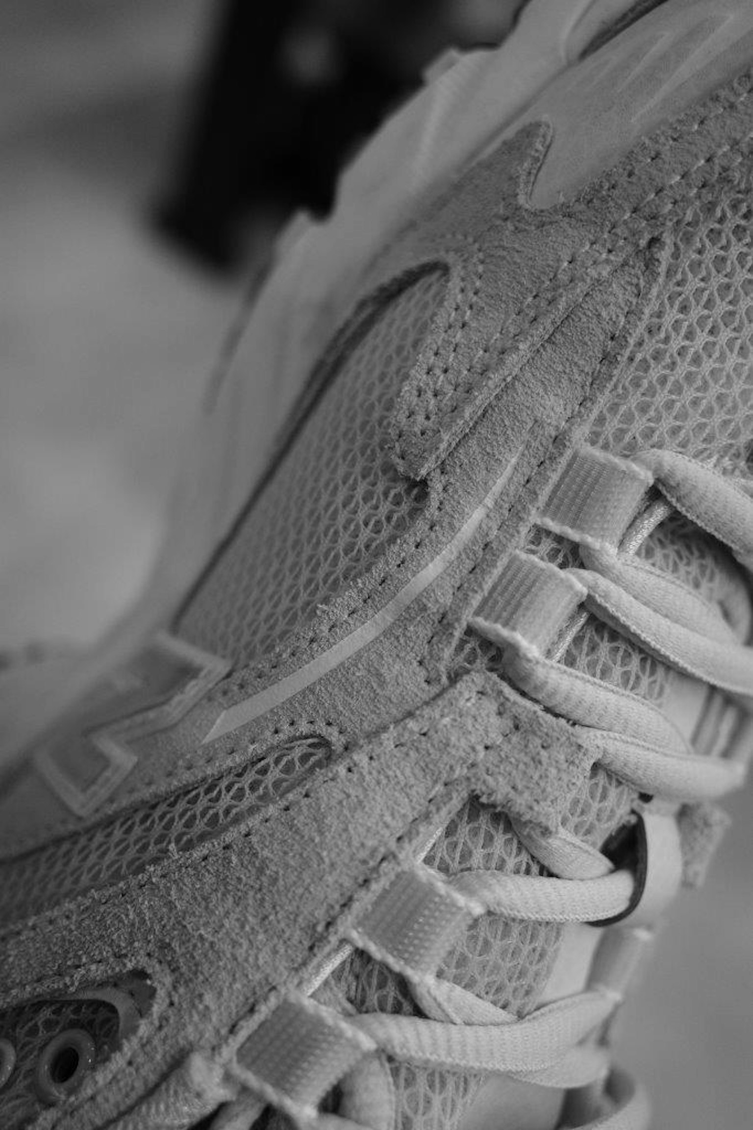 Nahaufnahme eines Sneakers in Schwarzweiß mit detaillierter Netz- und Schnürsenkelfunktion