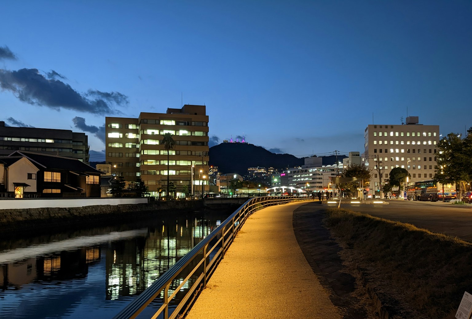夜晚河边景象，建筑物灯光在水面上倒影