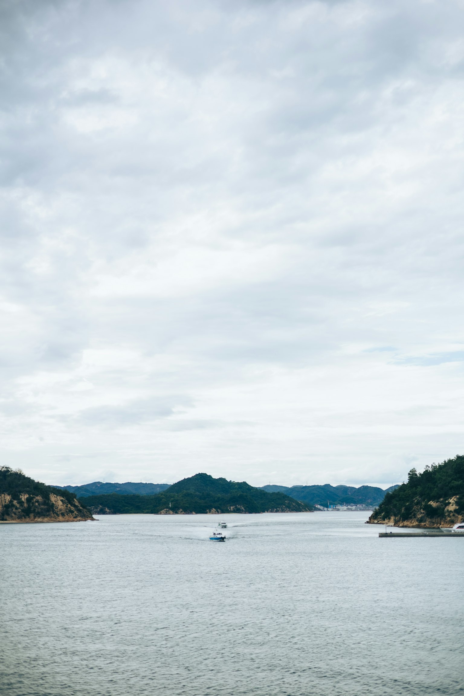 宁静的湖泊视野，远处有山和多云的天空