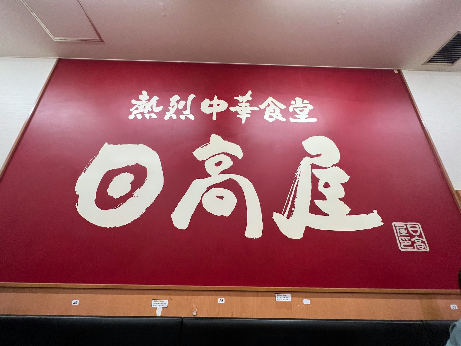 红色墙壁上有一个大招牌，写着中国餐厅的名称，字迹粗大
