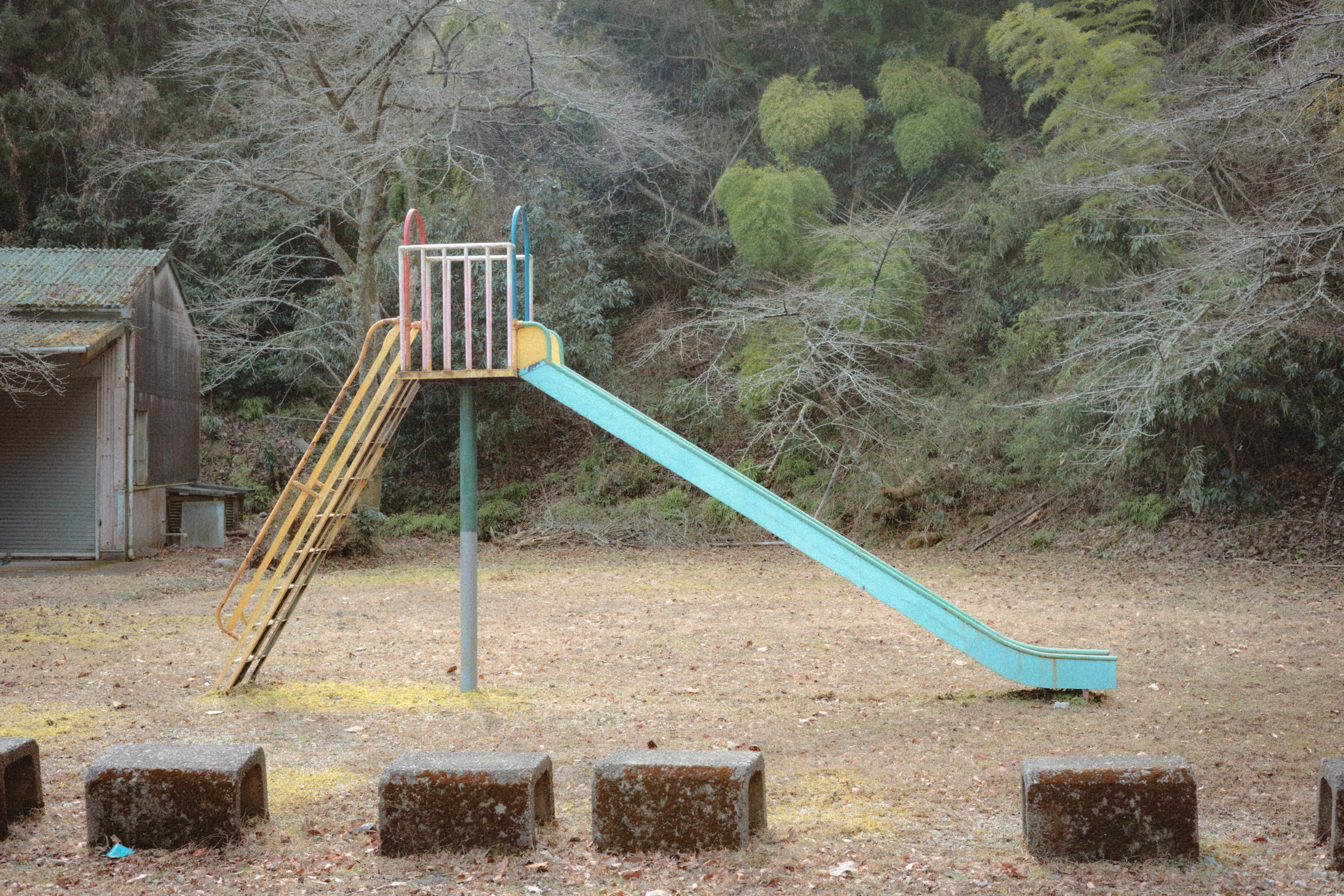 乾いた地面の遊具と砂場のある屋外公園の風景