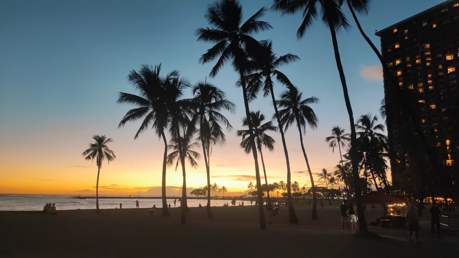 ทิวทัศน์ชายหาดที่สวยงามพร้อมต้นมะพร้าวและพระอาทิตย์ตก
