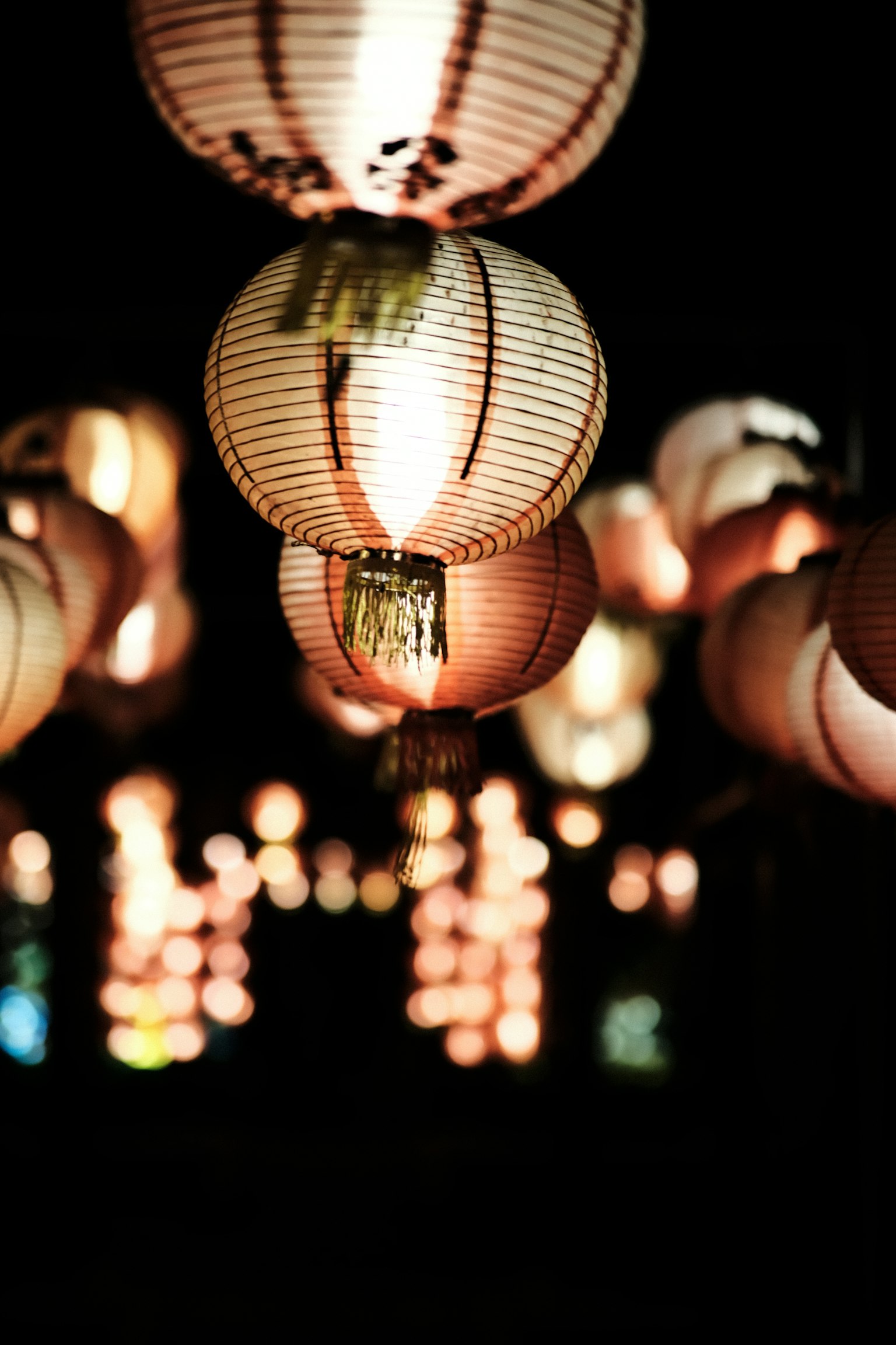 A cluster of beautiful lanterns glowing against a dark background