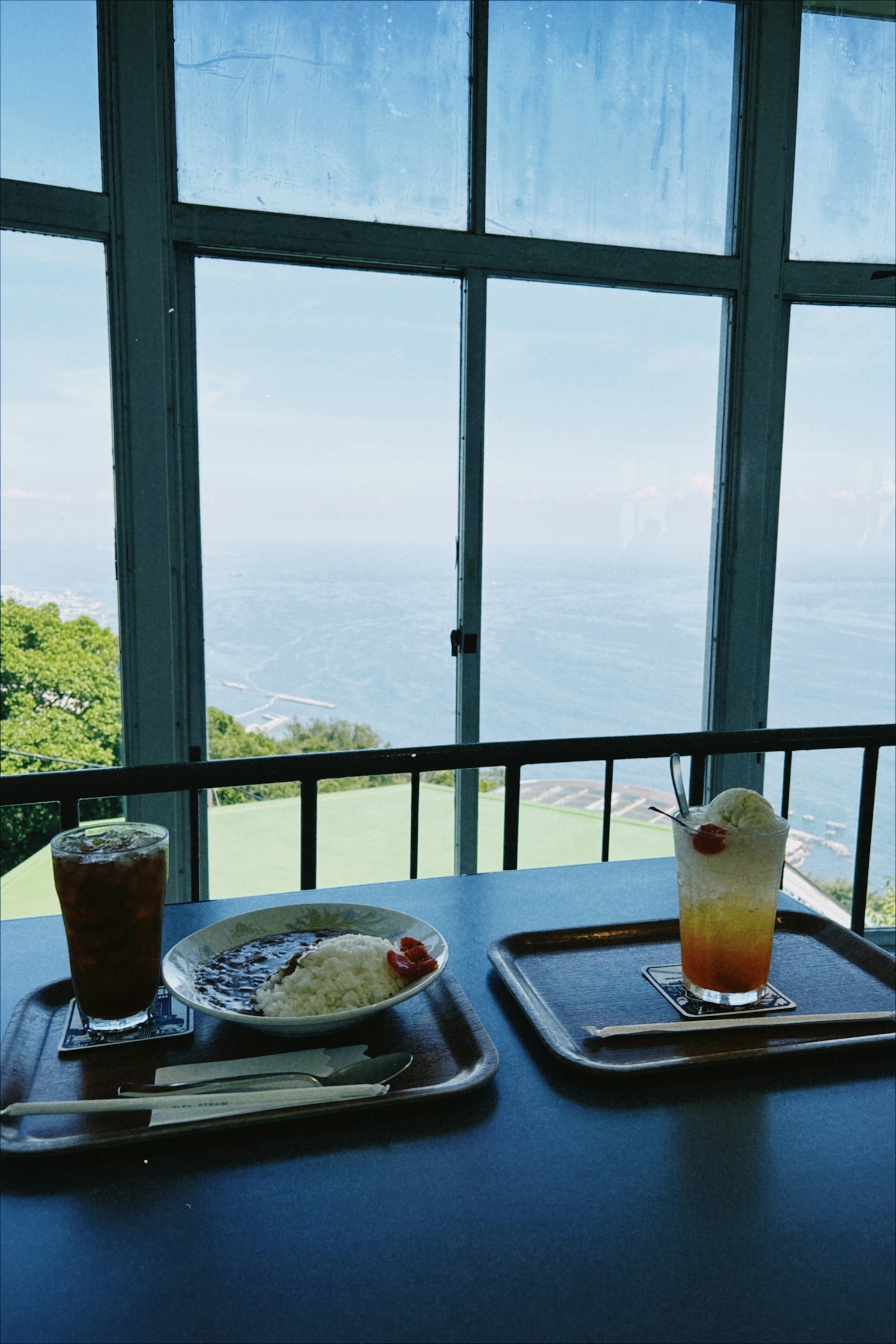 Dining scene with food and drinks at a cafe overlooking a scenic view