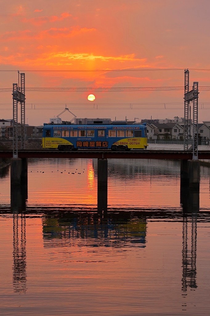 朝日に染まる石津川の鉄道橋と夕焼けの空