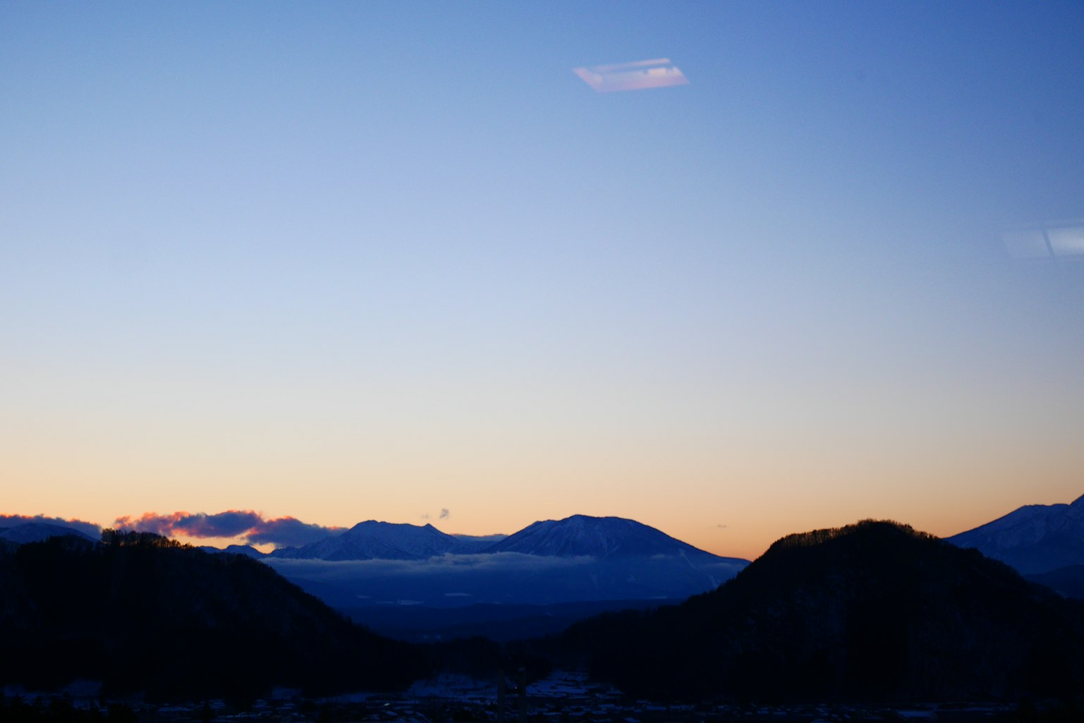 Pemandangan pegunungan saat senja dengan langit biru