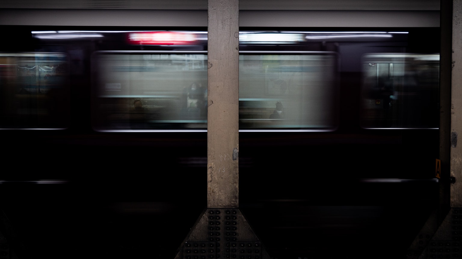 Blurred image of a moving subway train at a platform