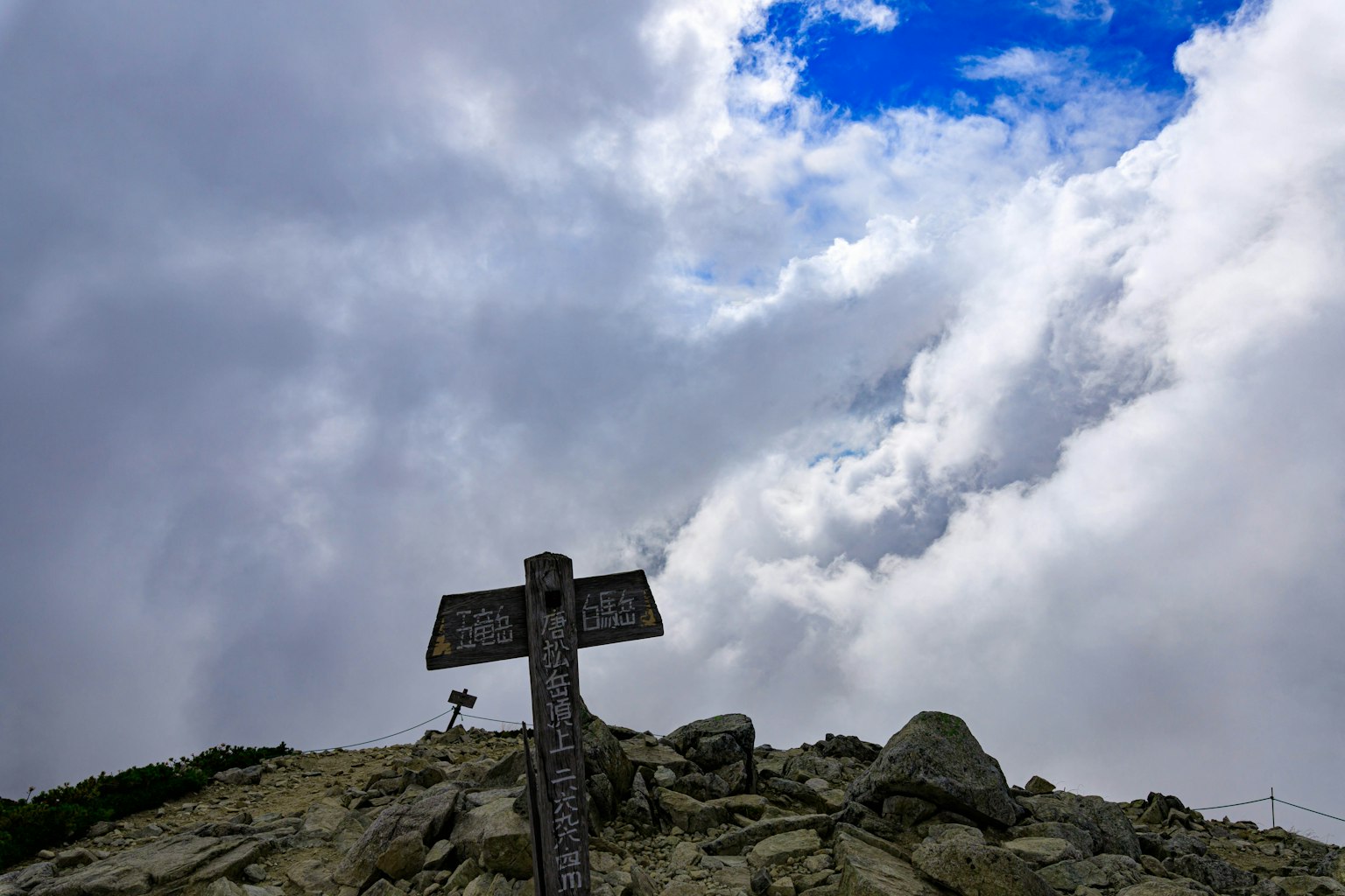 Panneau au sommet de la montagne avec ciel nuageux