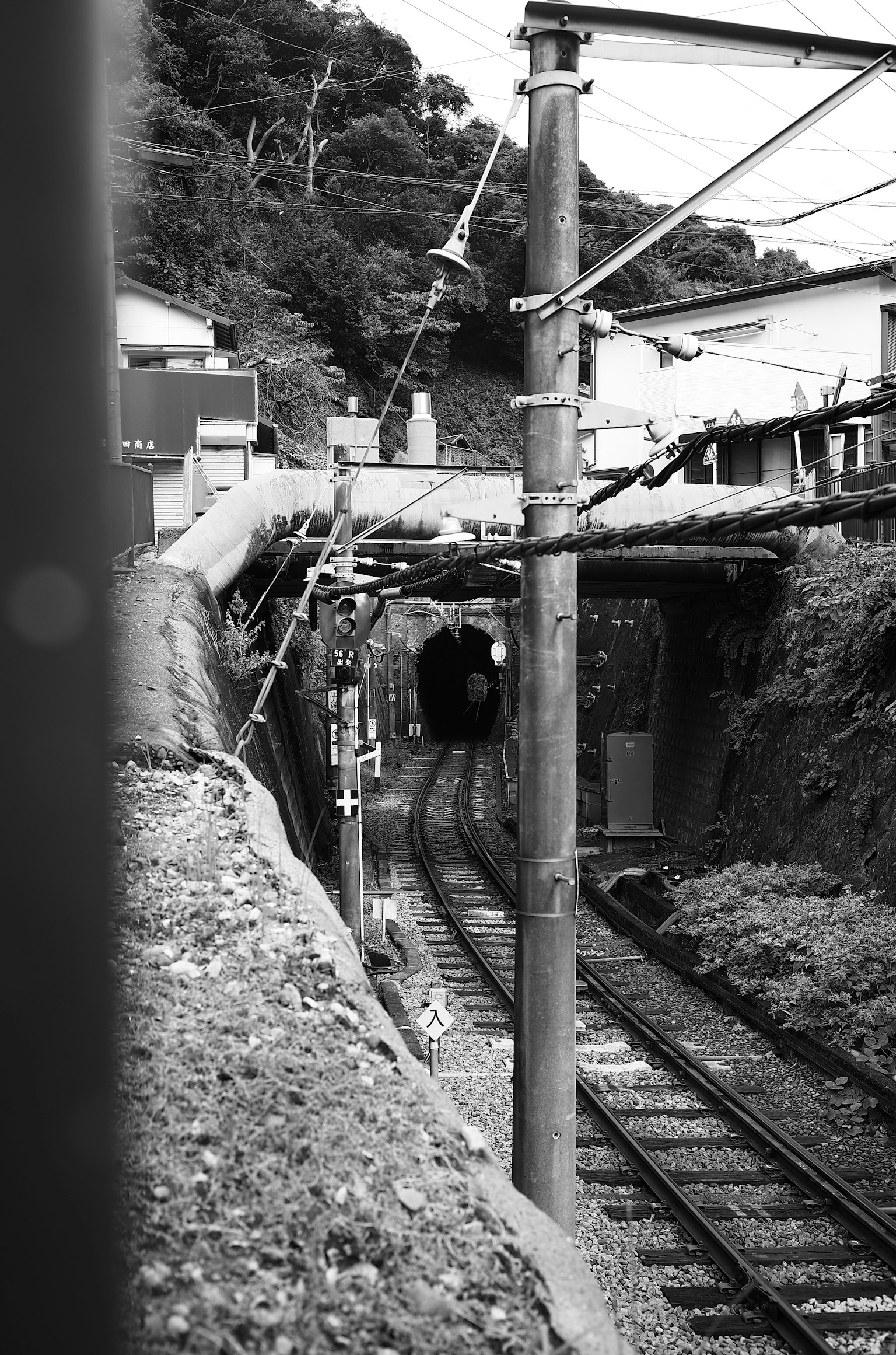 Black and white railway scene leading into a tunnel