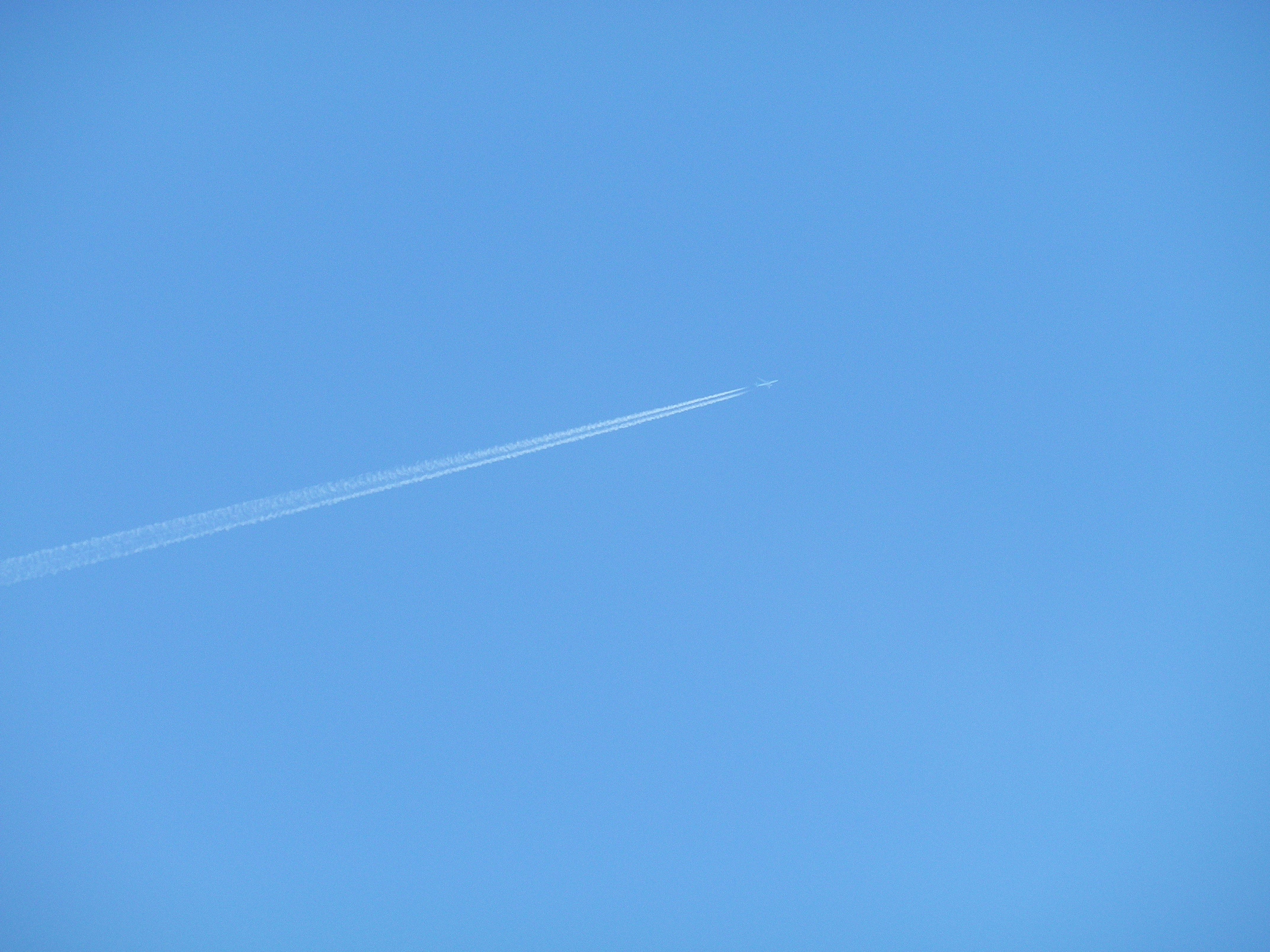 cielo blu con una scia di aereo
