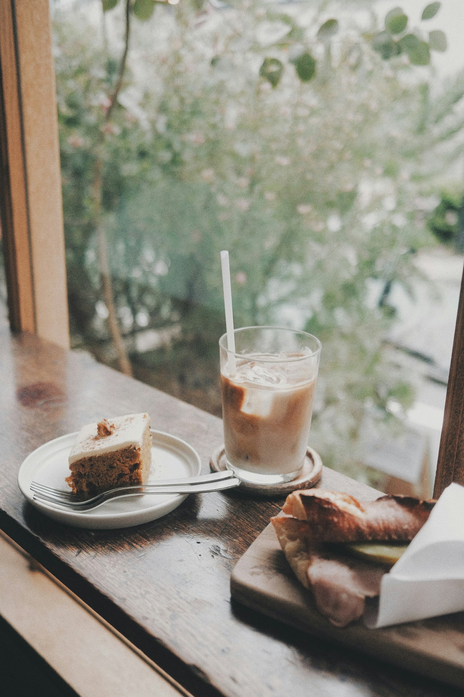 Iced coffee and cake plate on a windowsill