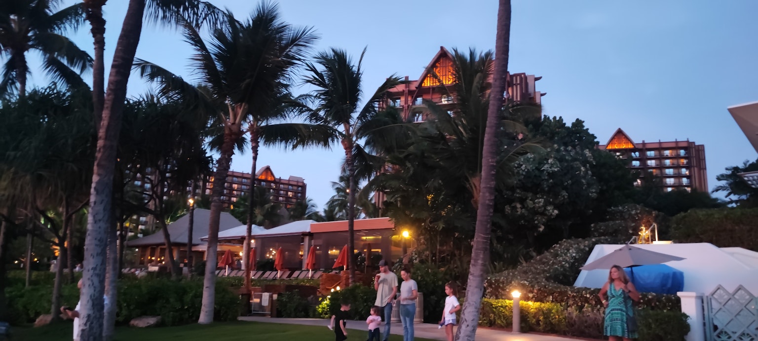 Abendansicht eines Resorthotels mit Palmen und Familien