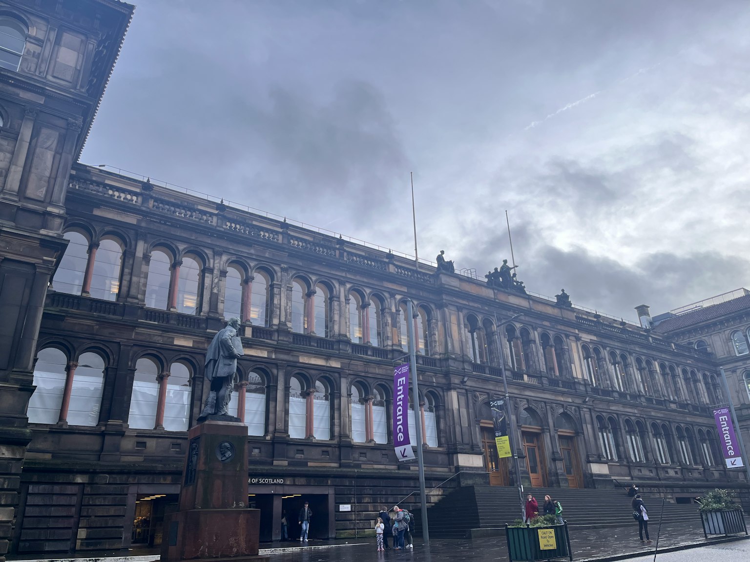 Historic building exterior featuring a statue and cloudy sky