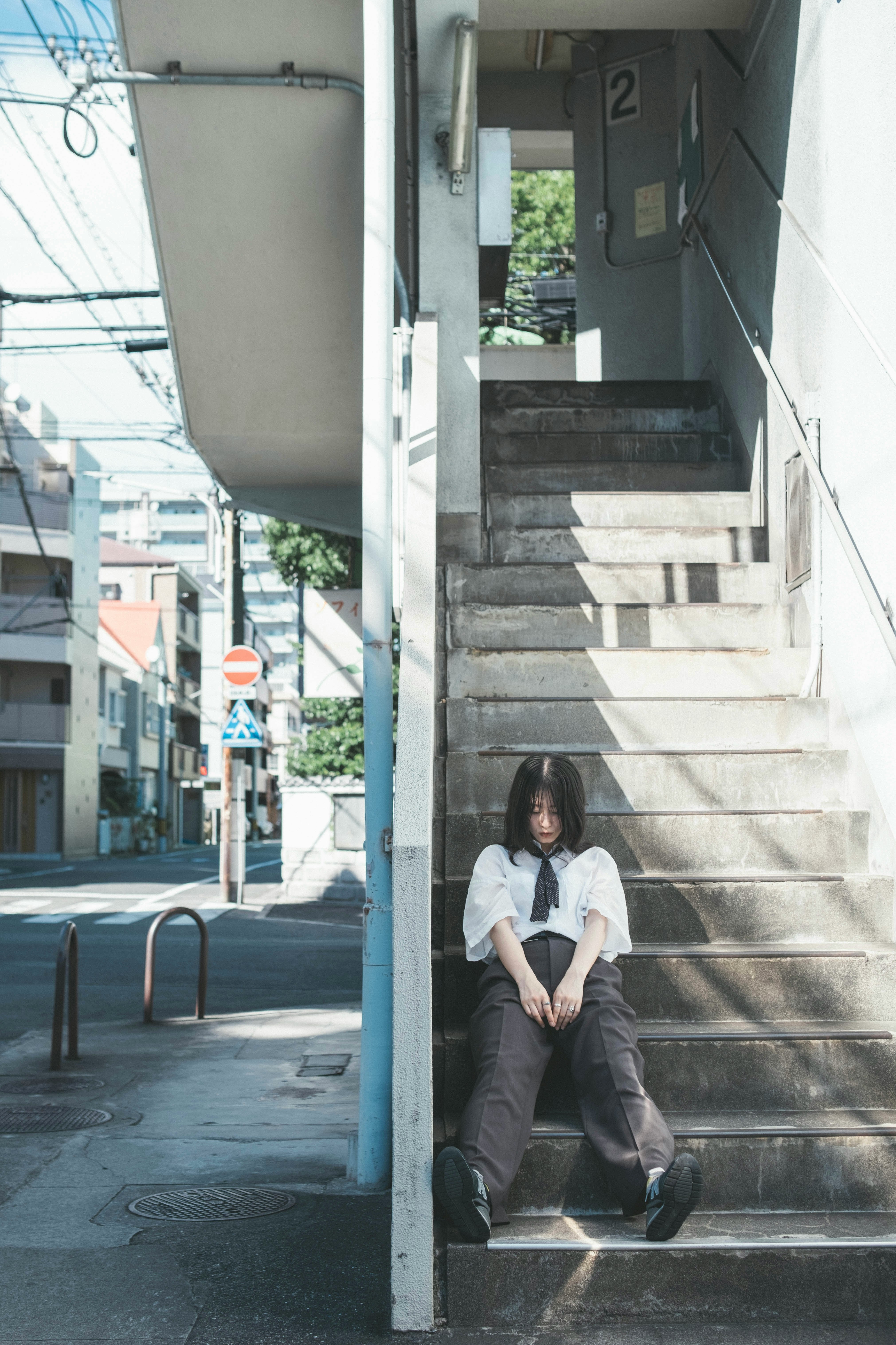 巷子裡樓梯上坐著的女性