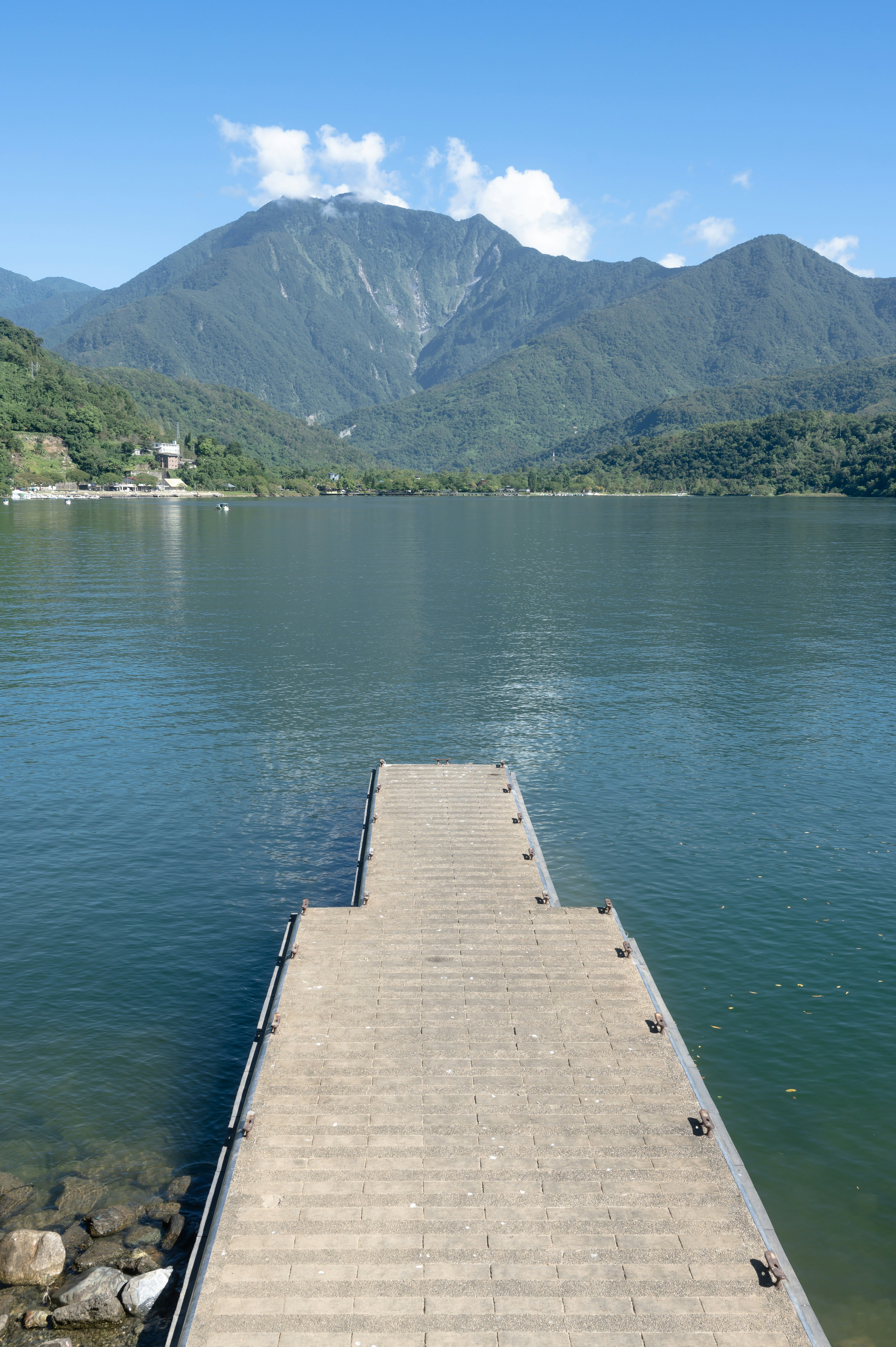 湖に突き出た桟橋と山並みの風景