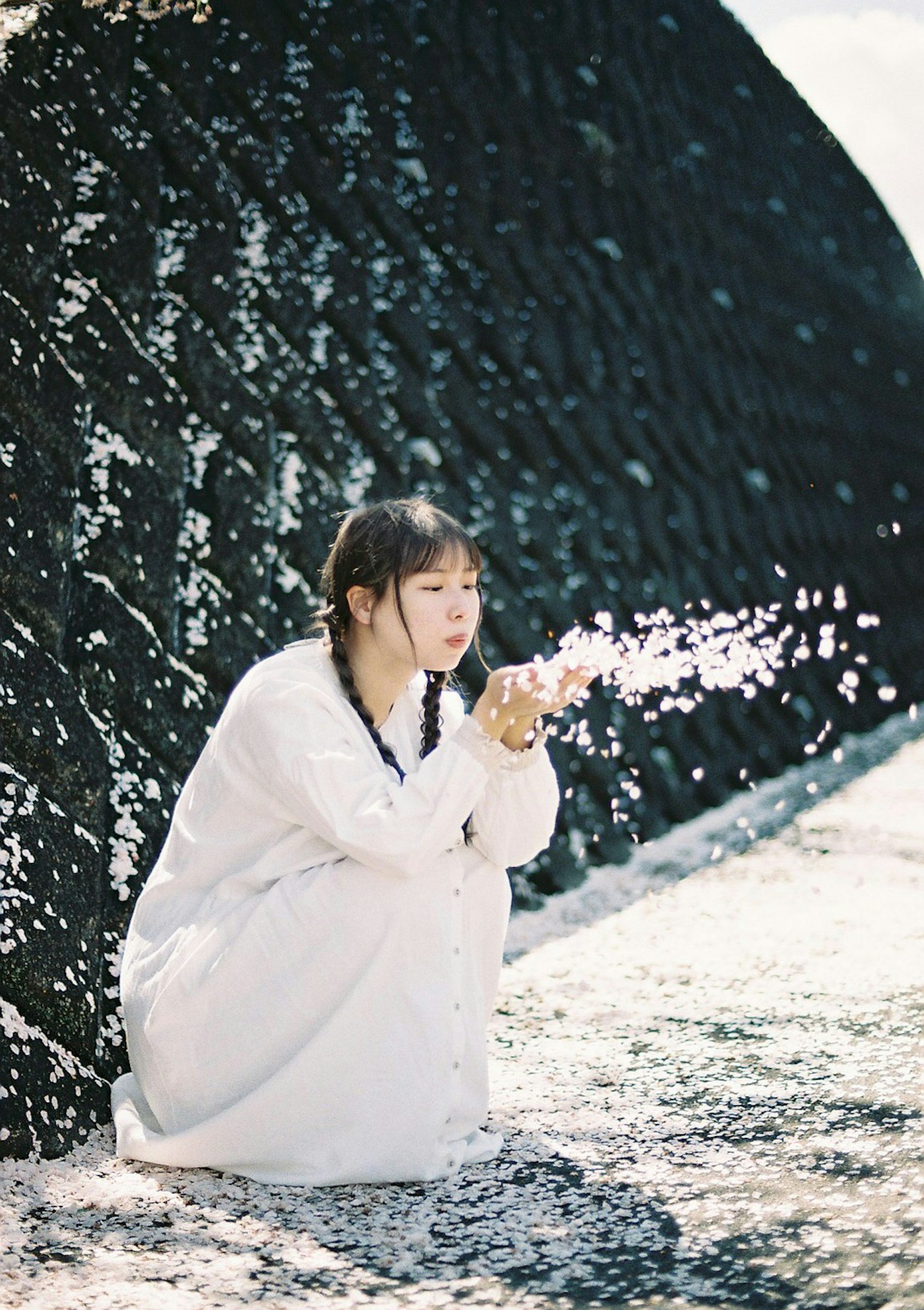 Donna in abito bianco che soffia gocce d'acqua