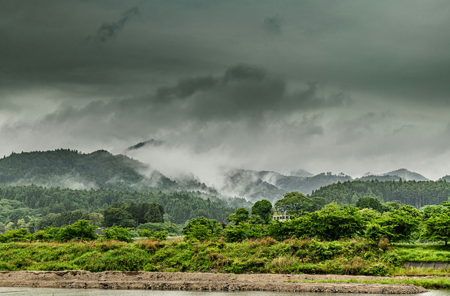 Lush green mountains under a cloudy sky
