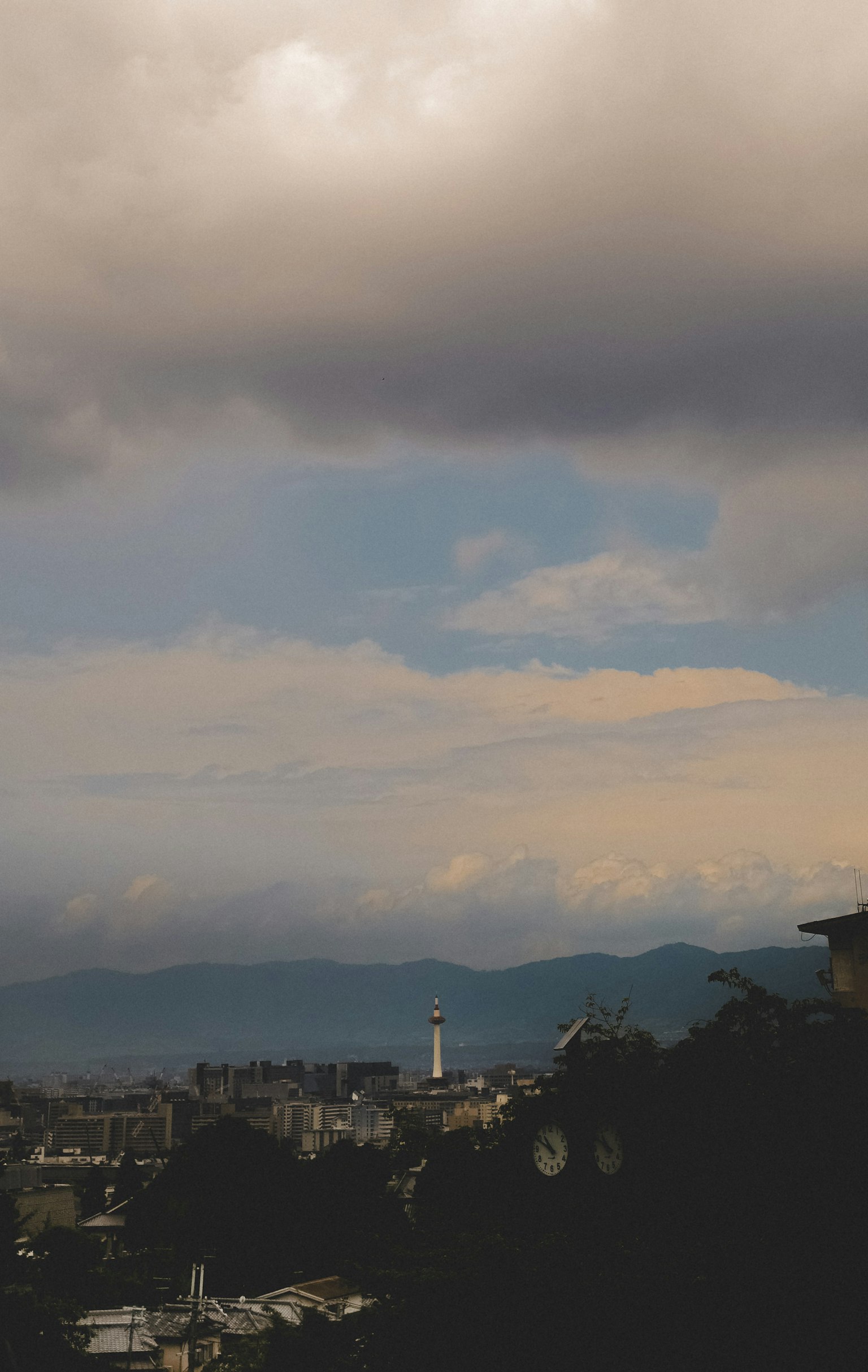 Panorama urbano sotto un cielo nuvoloso con montagne lontane