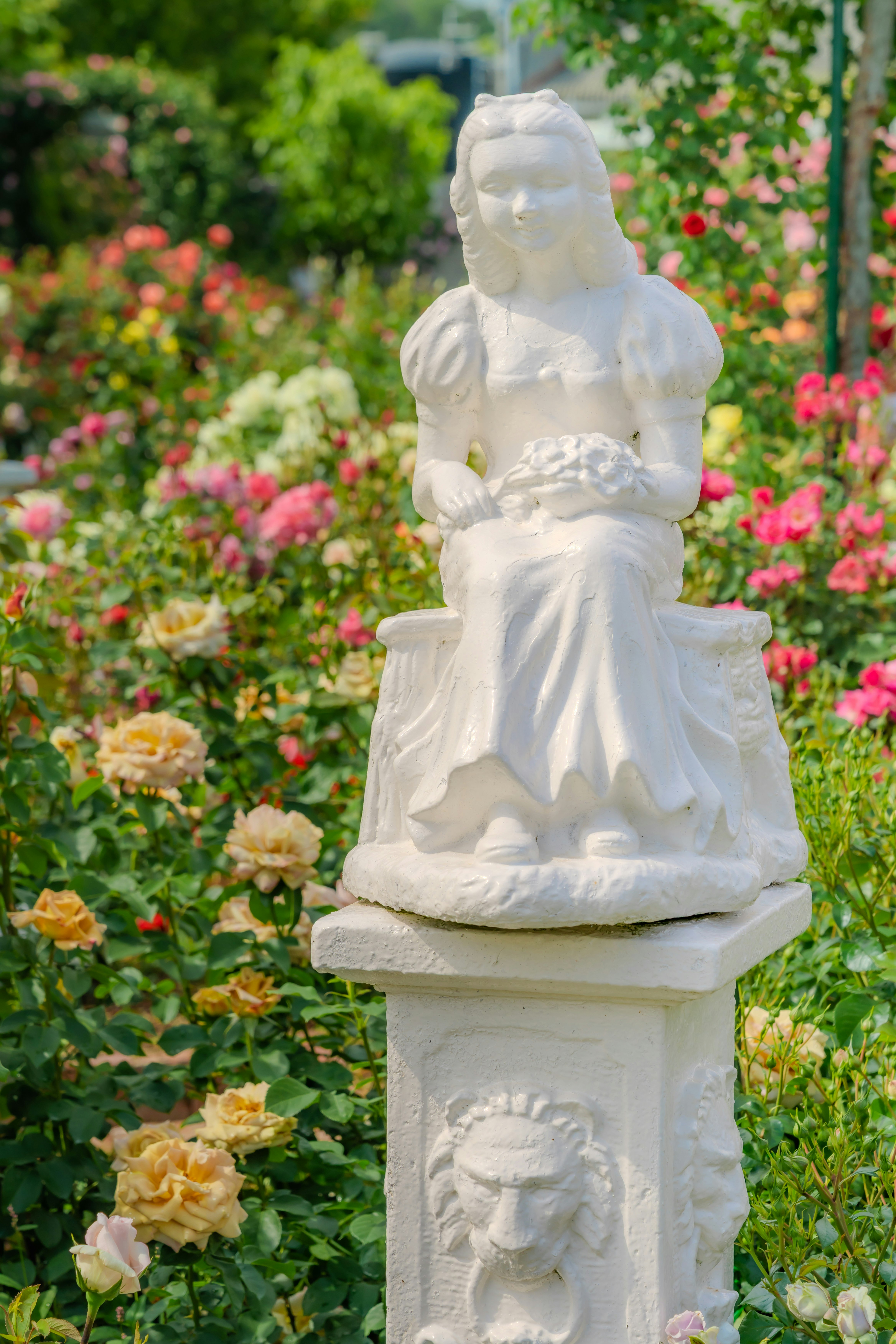 花畑の中に置かれた白い仏像の像