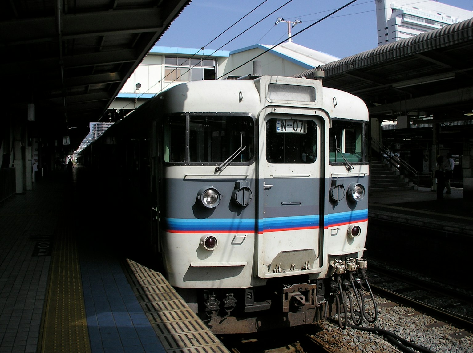 รถไฟสีขาวมีแถบสีน้ำเงินที่สถานี