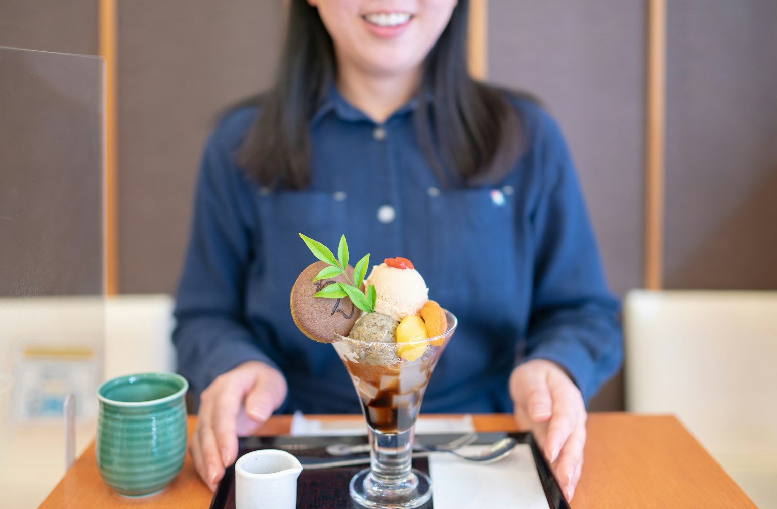 女性展示带有各种冰淇淋和配料的甜点