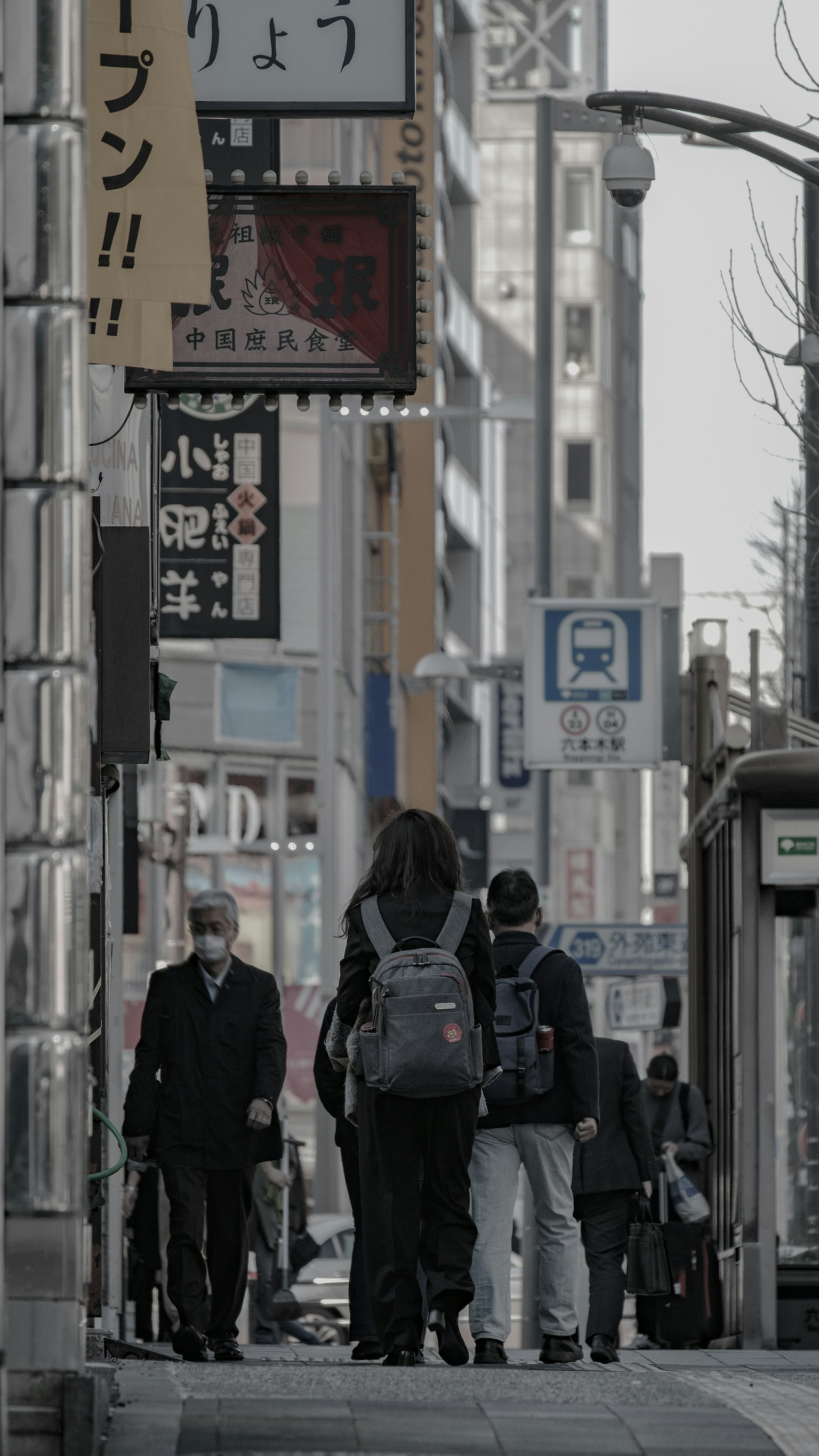 Strada cittadina con pedoni e insegne commerciali