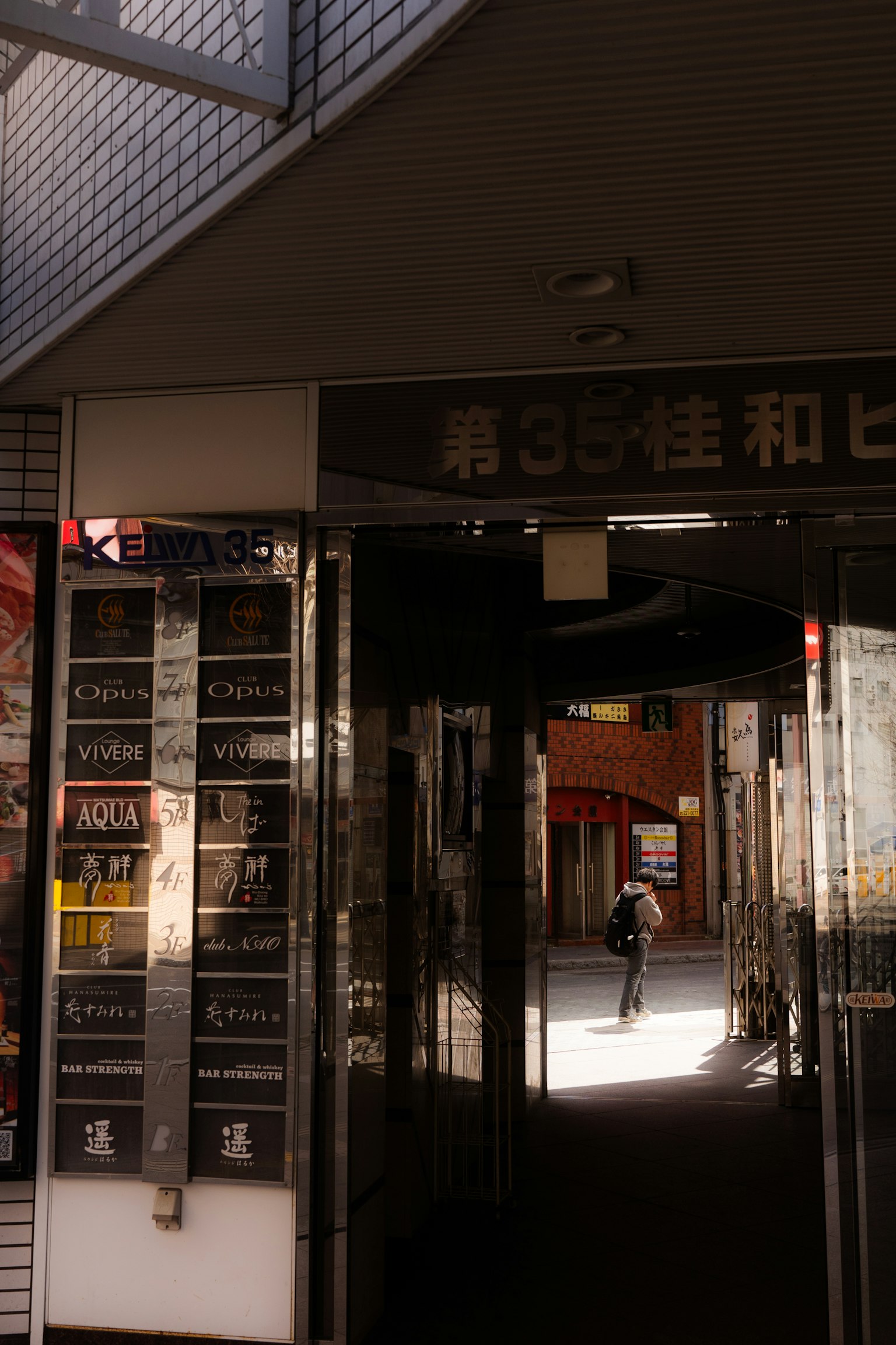 面向明亮街道的商業建築入口處，有人走過