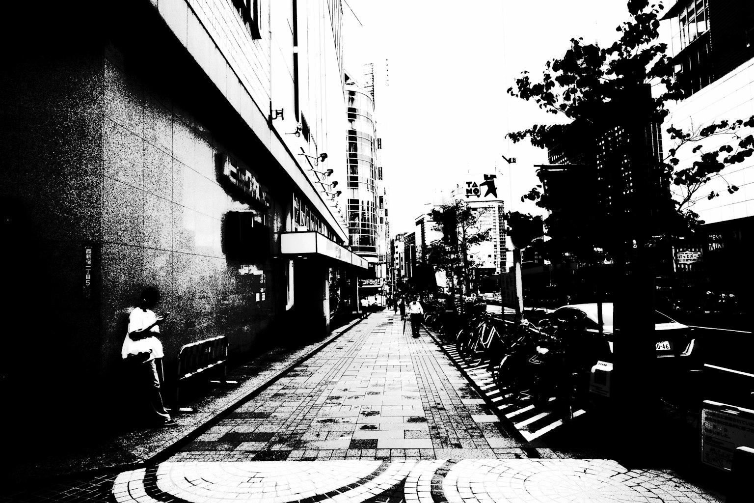 黑白街道上坐著一個人和商業建築的側面