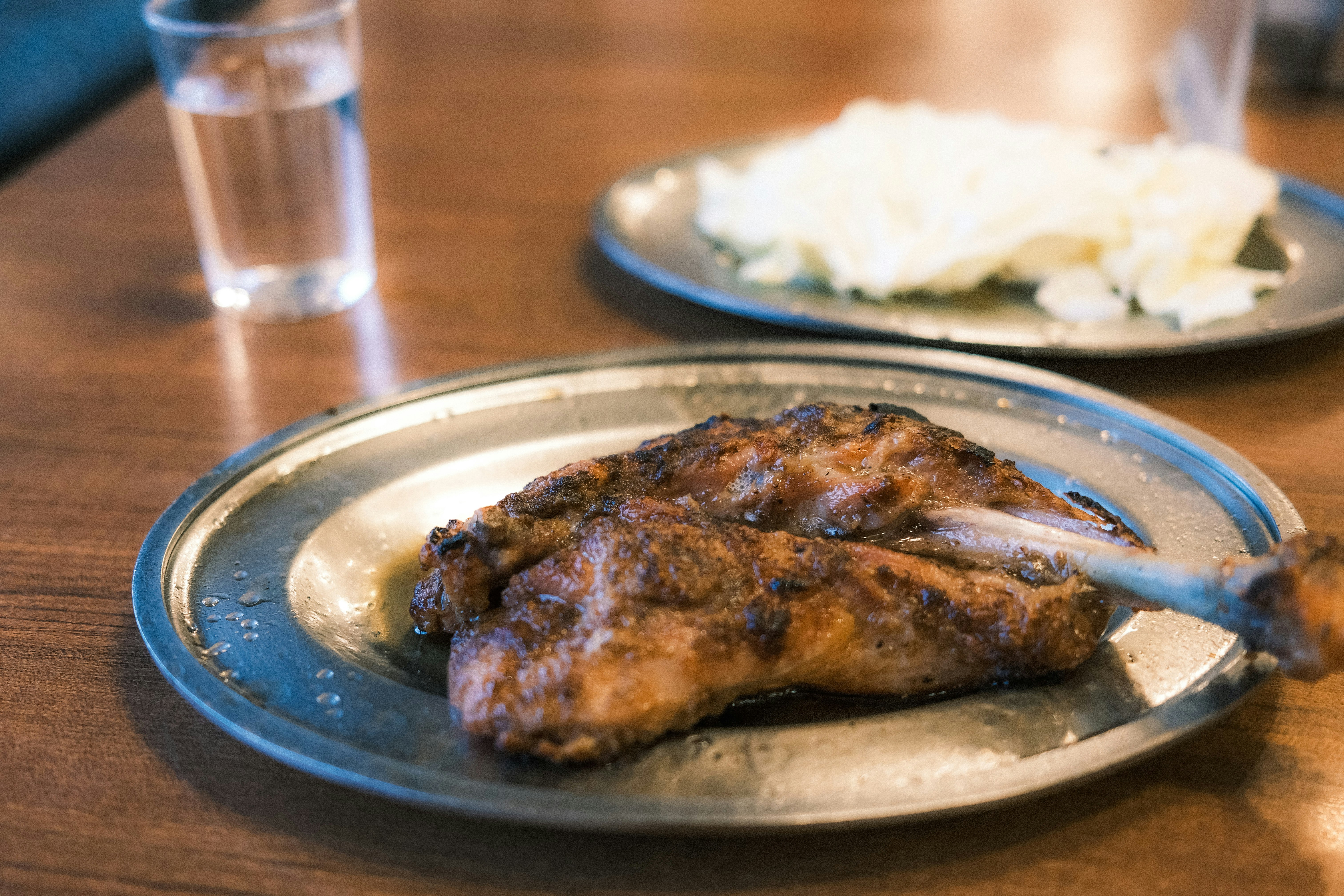 gegrillter Fisch auf einem Teller auf einem Holztisch