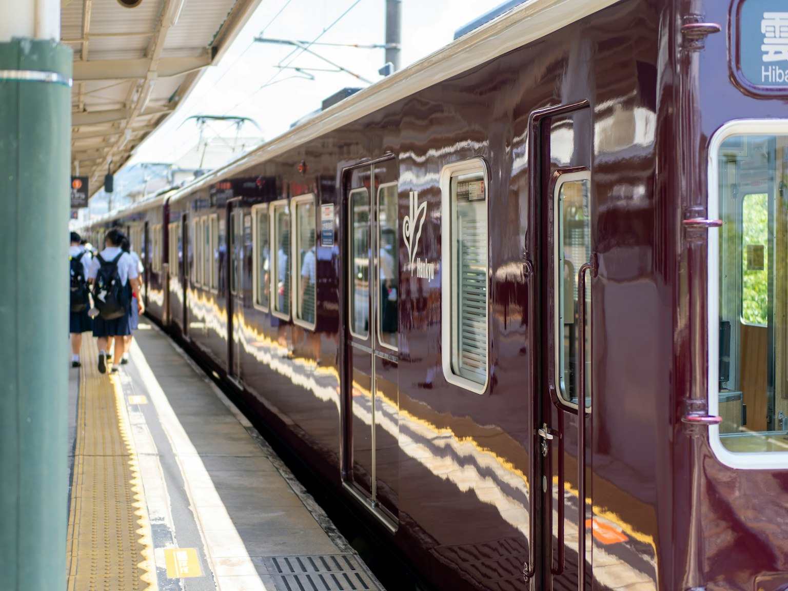 Un train violet sur un quai de gare avec des passagers montant