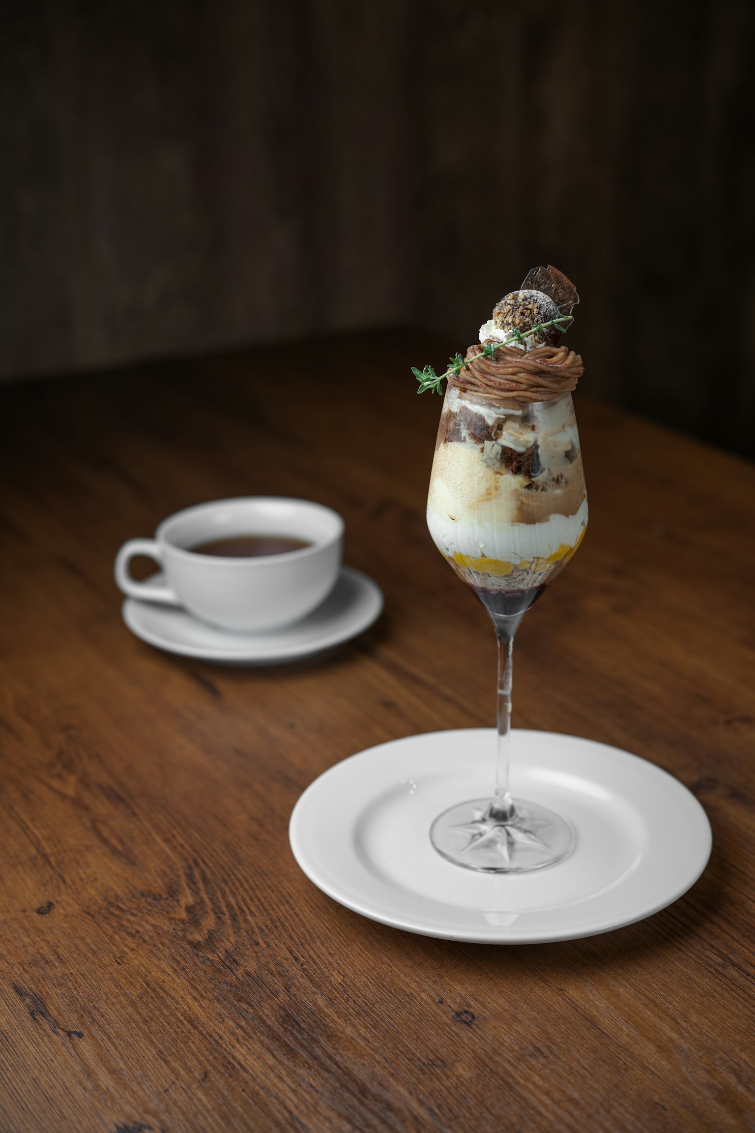Elegante vaso de postre lleno de parfait y una taza de café
