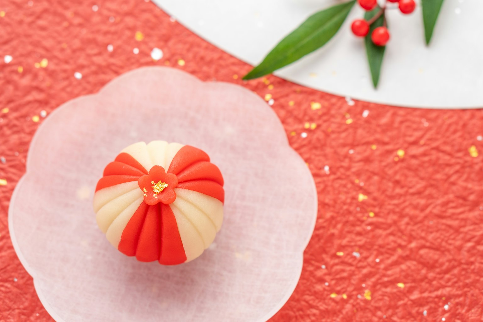 Un hermoso wagashi rojo y blanco en un plato en forma de flor