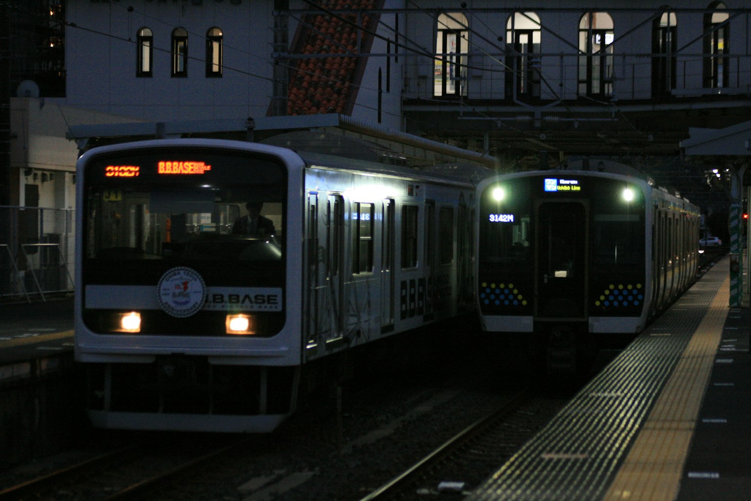 夜間停在車站的兩列火車和背景建築