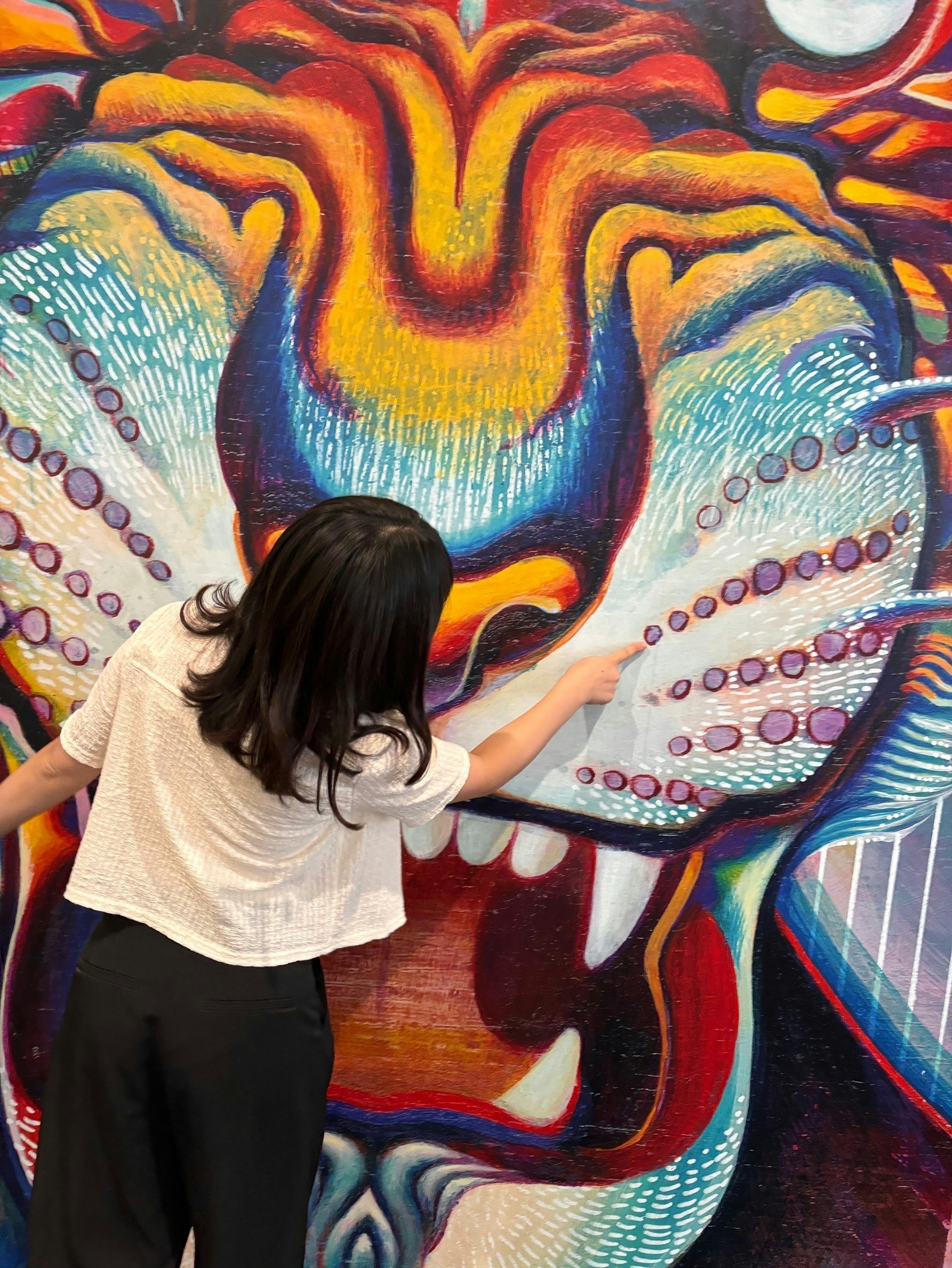 Child looking up at a colorful mural
