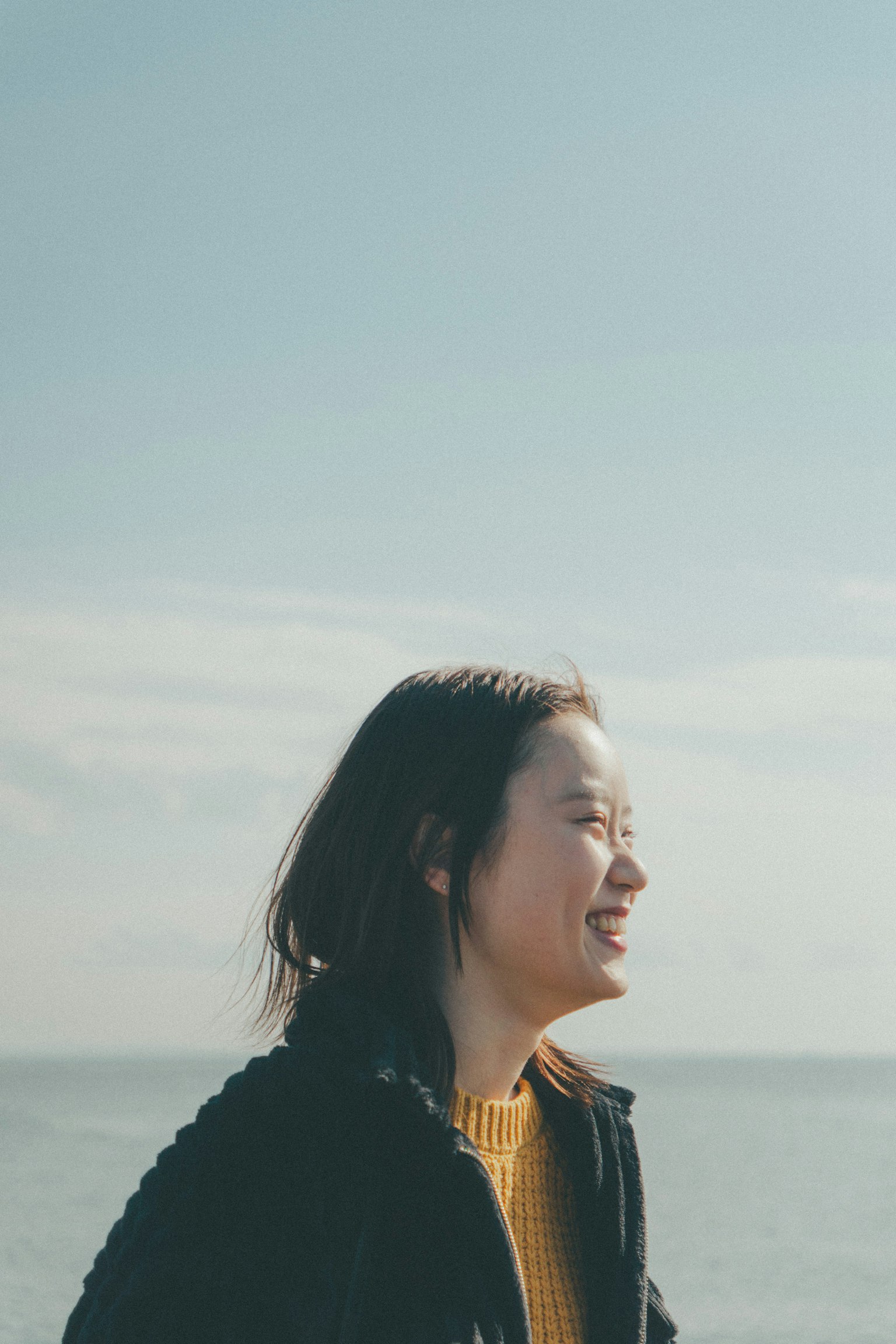 Profil d'une femme souriante sous un ciel bleu