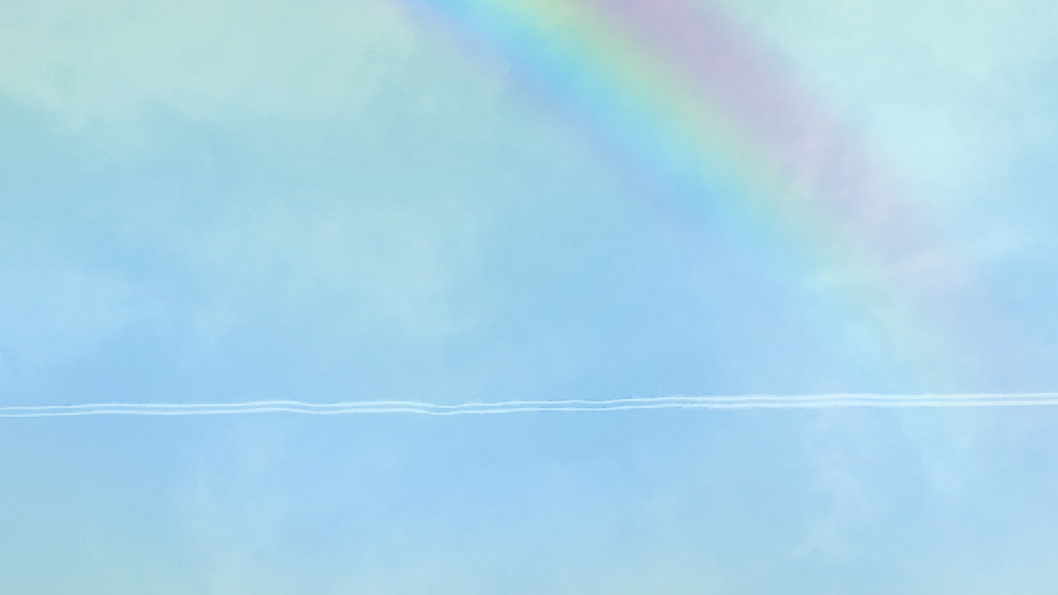 Pelangi di langit biru dengan awan lembut