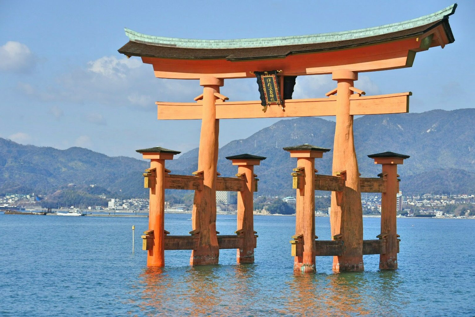 Cảnh đẹp của cổng torii đứng trong nước với dãy núi ở phía sau