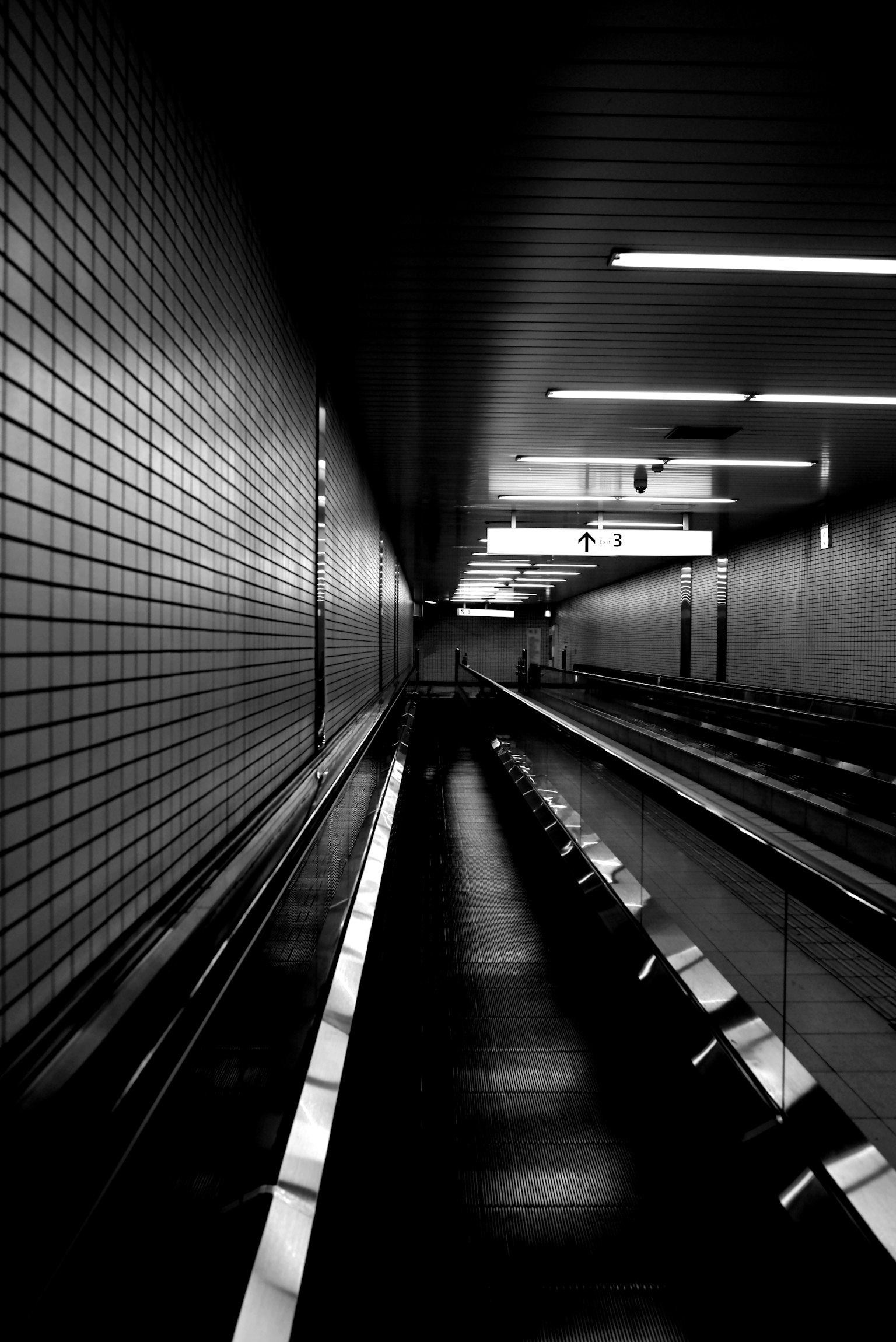 Long couloir dans un tunnel sombre avec des murs carrelés