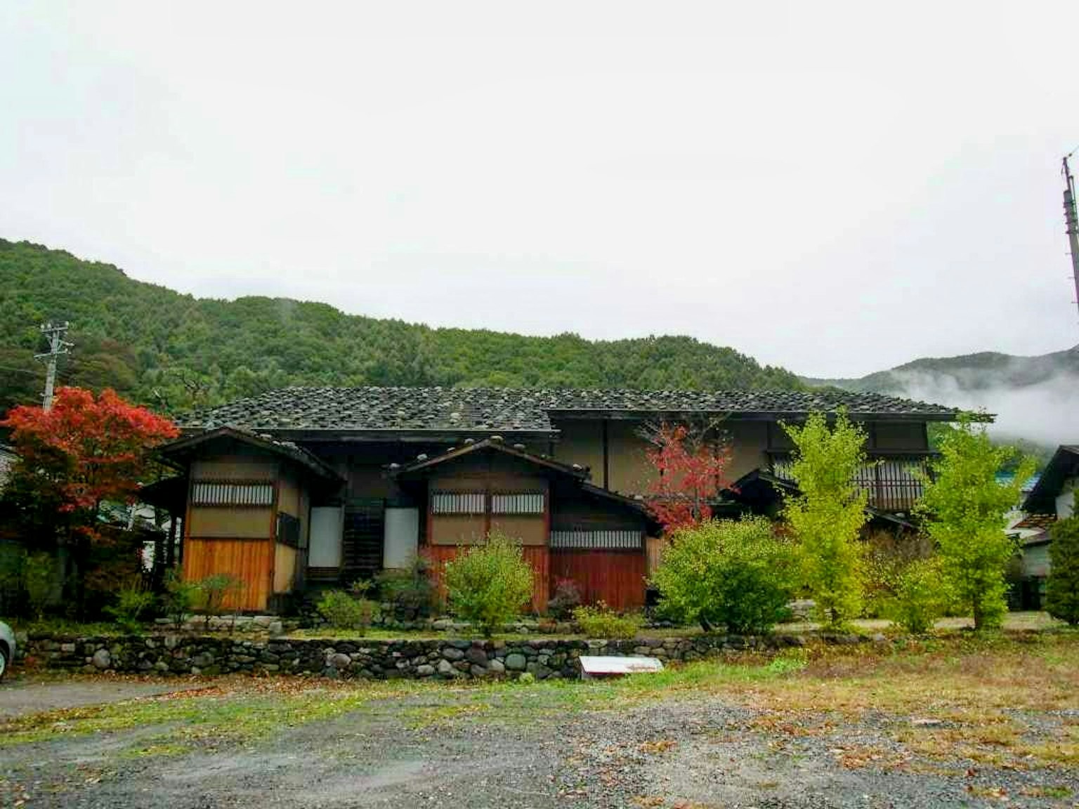 Traditionelles japanisches Haus umgeben von üppigem Grün und Bergen