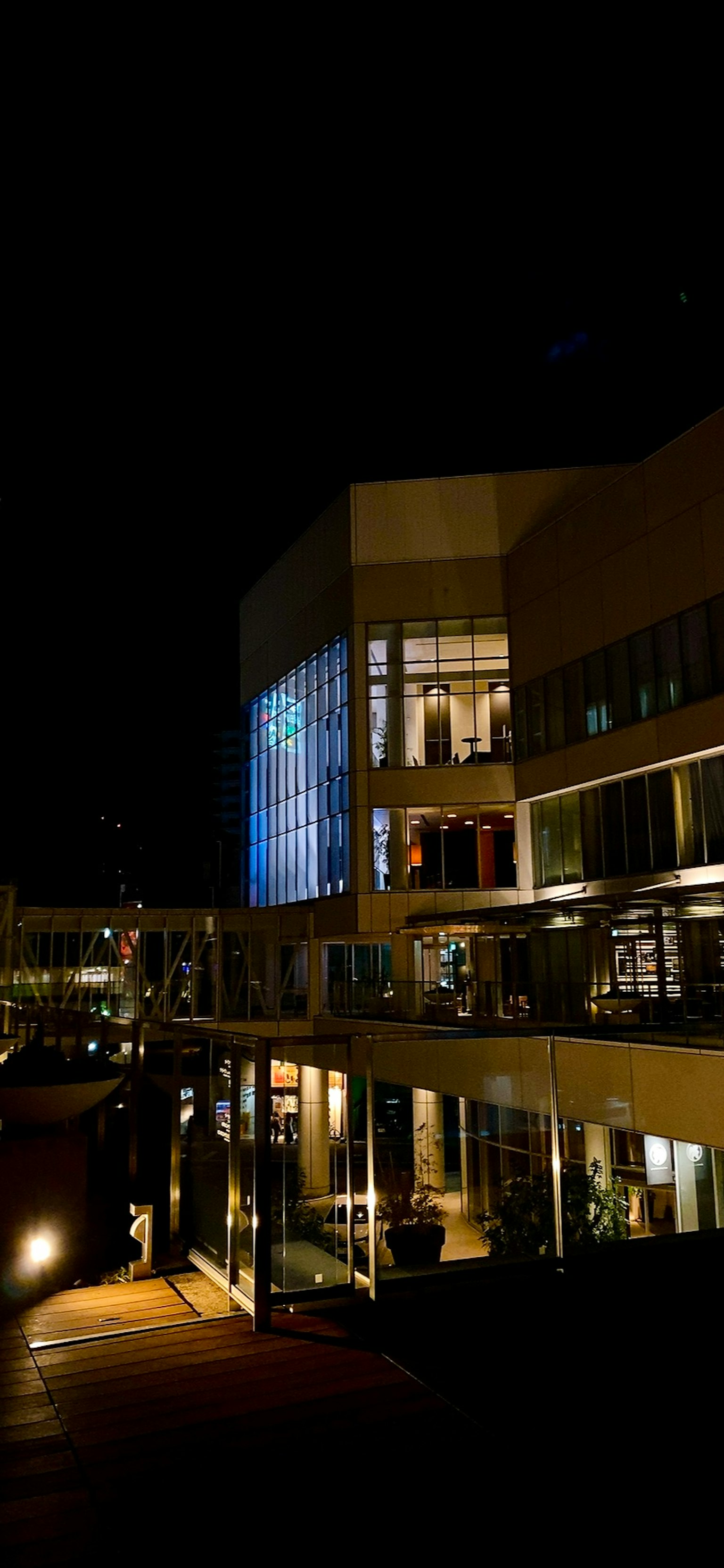 Vista notturna di un edificio e di una terrazza con illuminazione e riflessi splendidi