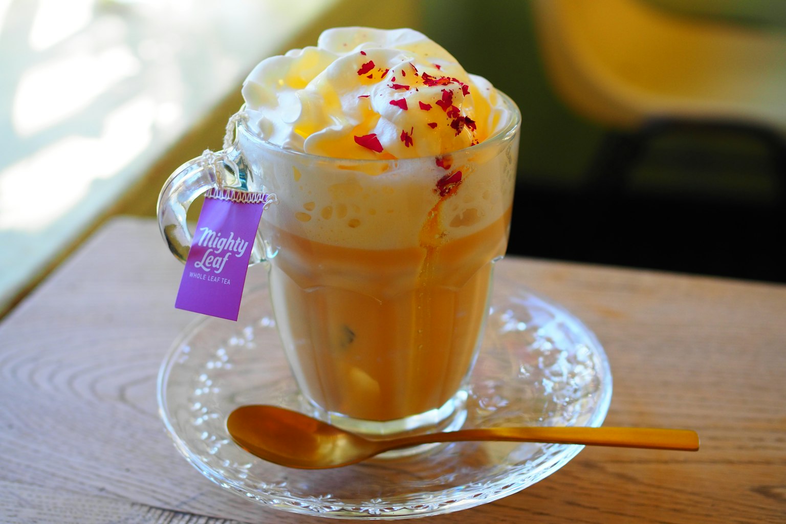A drink in a cup topped with cream and flower petals