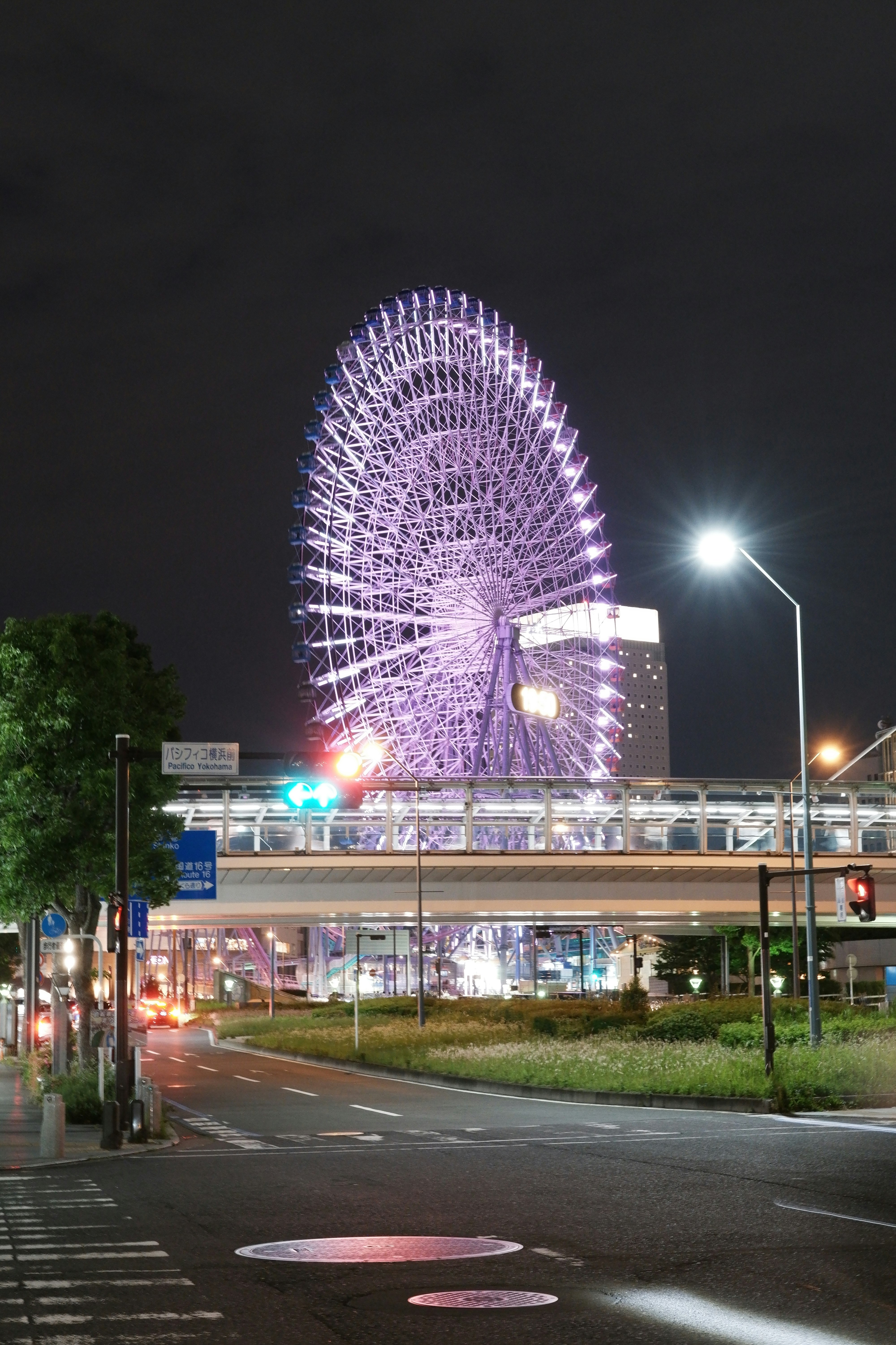 夜の観覧車が見える街の交差点の風景