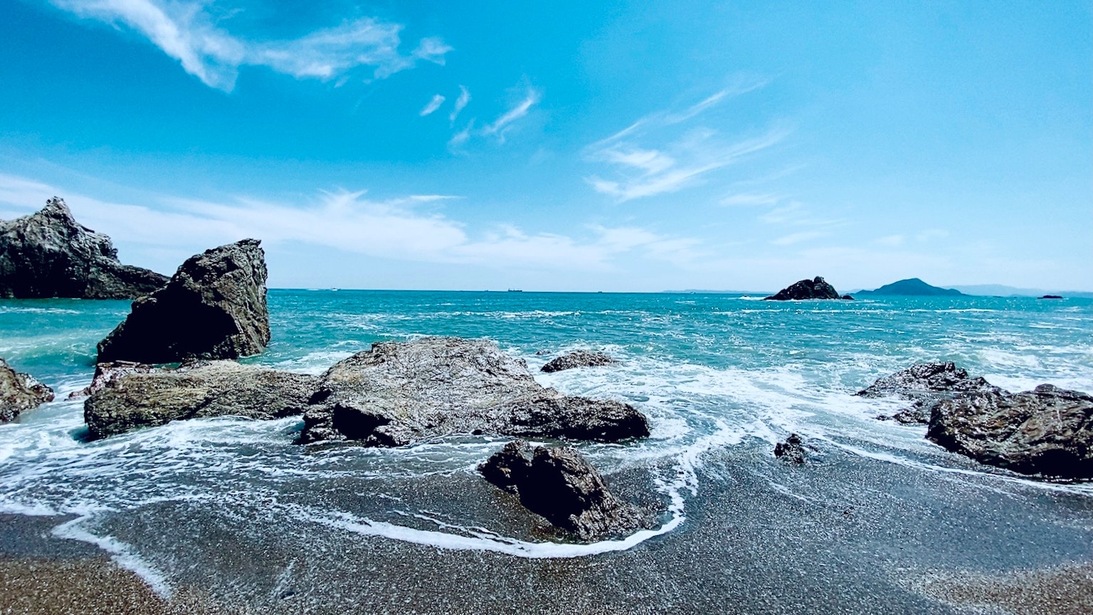 Pemandangan pantai yang indah dengan lautan biru dan formasi batu