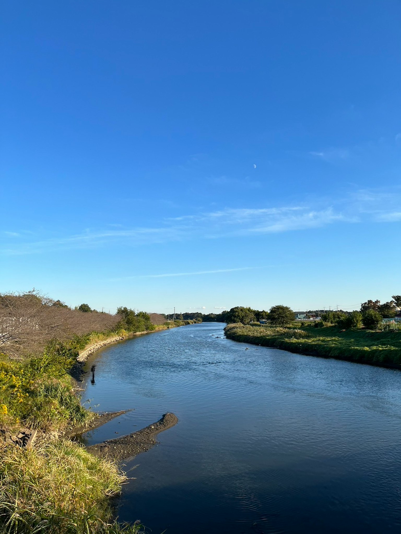 Une rivière sereine coulant sous un ciel bleu clair