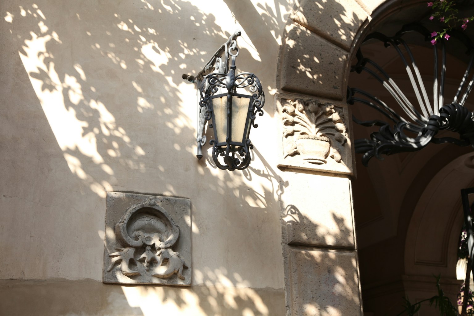 Lámpara decorativa montada en una pared con patrones de sombra intrincados